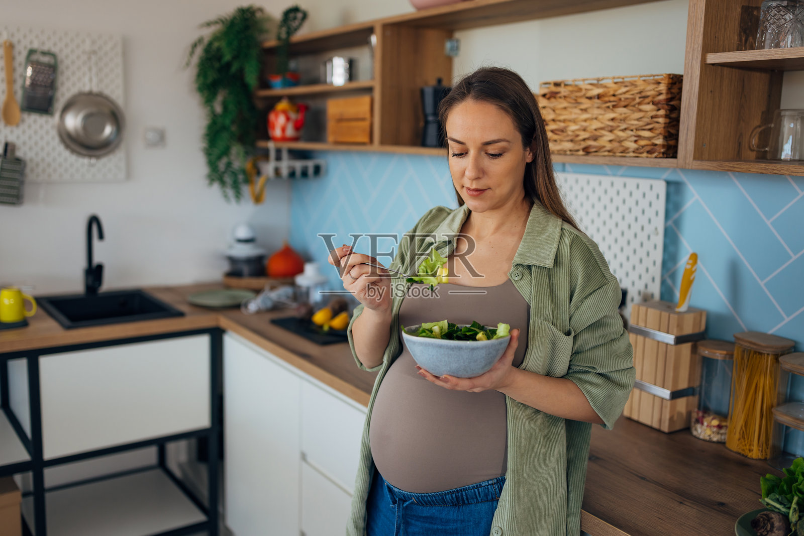 一位孕妇在厨房享用富含维生素和矿物质的健康有机沙拉作为早餐照片摄影图片