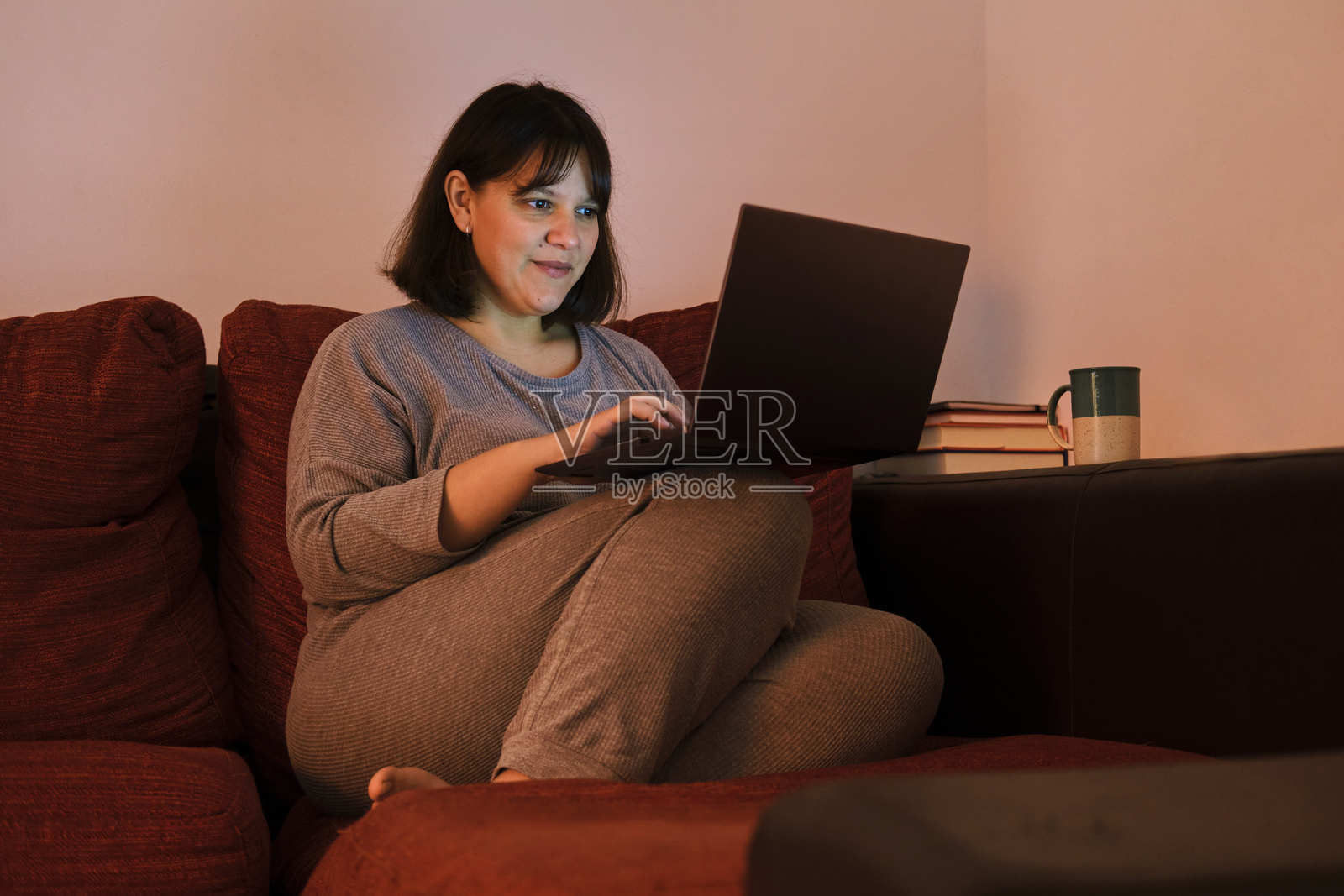 女人在家中沙发上放松，使用笔记本电脑照片摄影图片