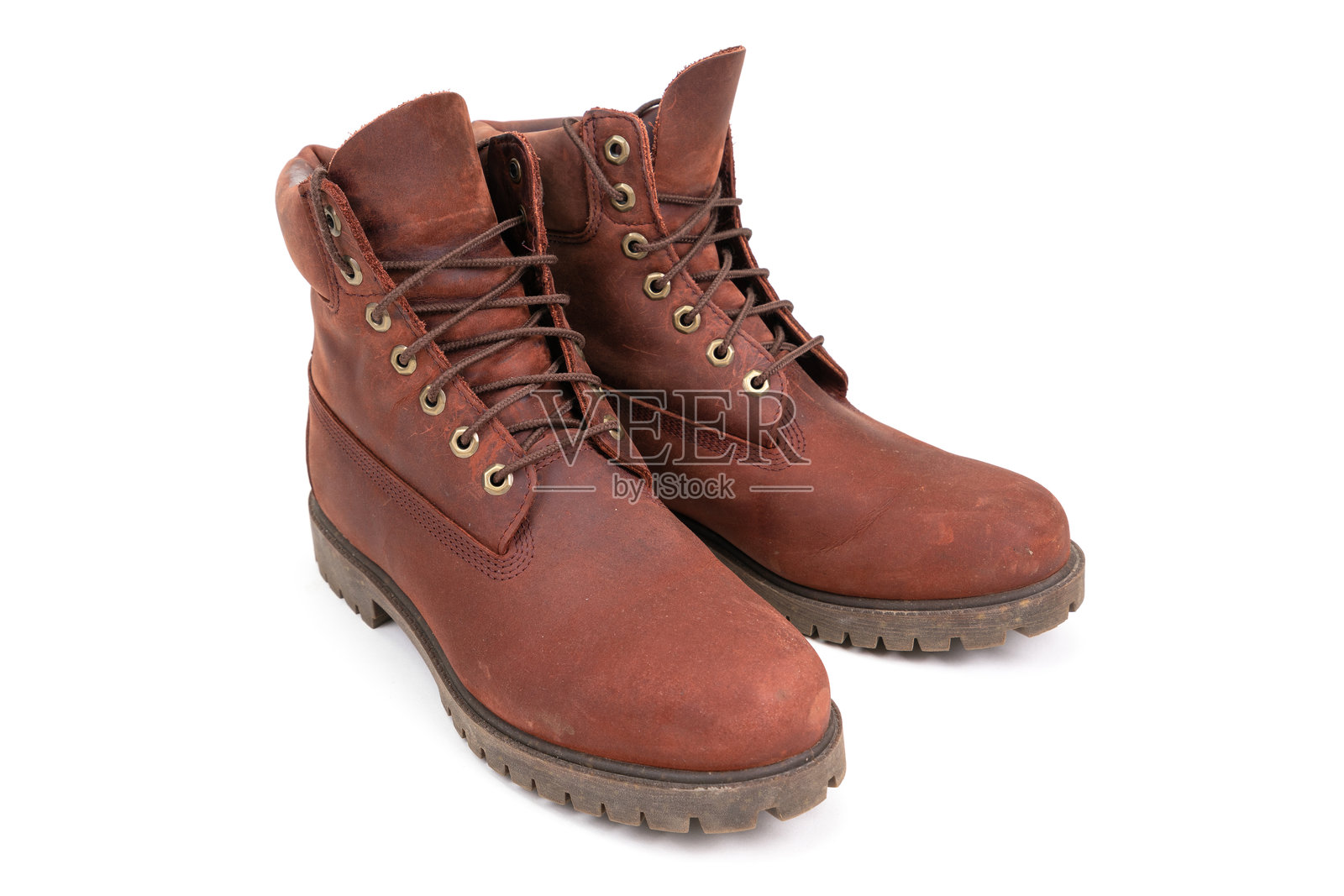 一双磨损的棕色皮靴，孤立在白色背景上。照片摄影图片