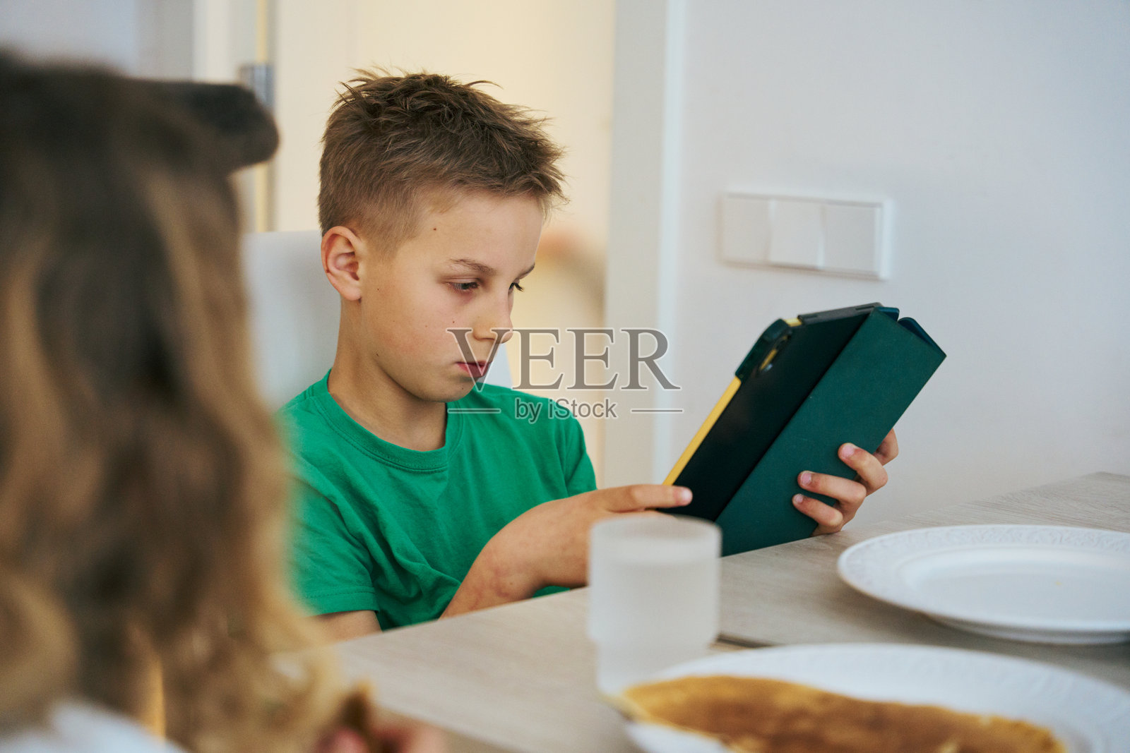 小男孩在家早餐时使用平板电脑照片摄影图片