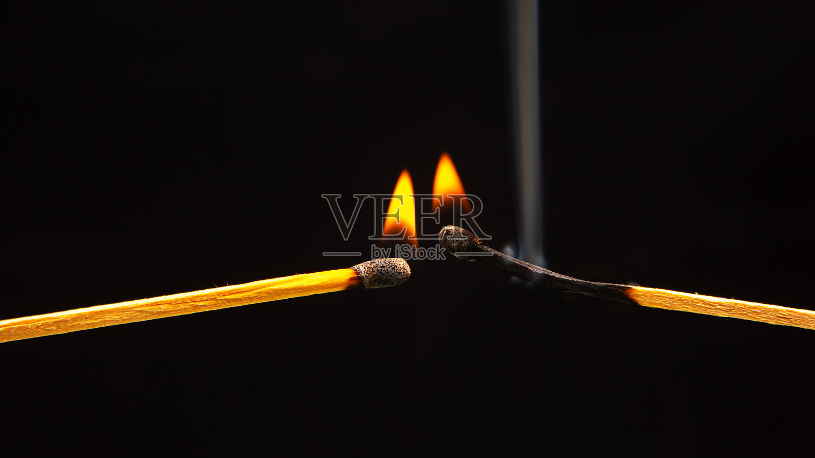 黑暗背景下的燃烧木柴火柴特写。燃烧的树木火焰照片摄影图片