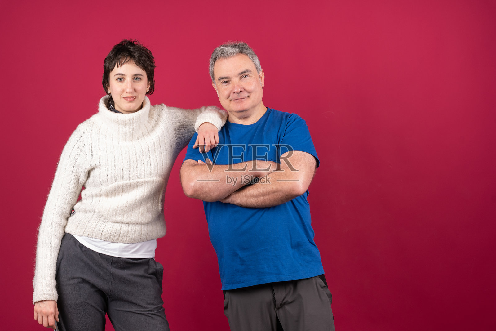 父女微笑着相互依偎，双臂交叉。照片摄影图片