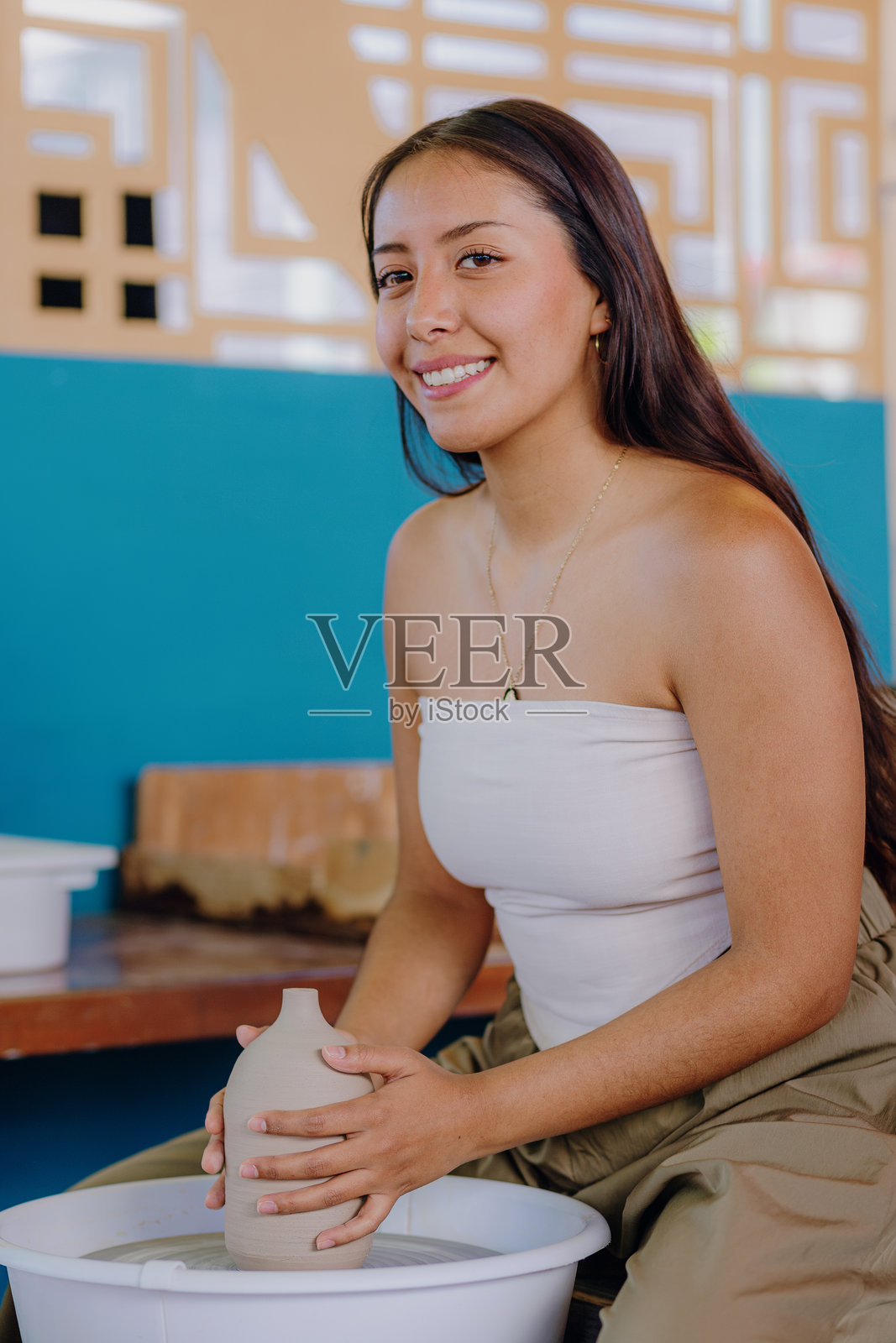 拉丁裔女性在工作室分析手工陶瓷照片摄影图片