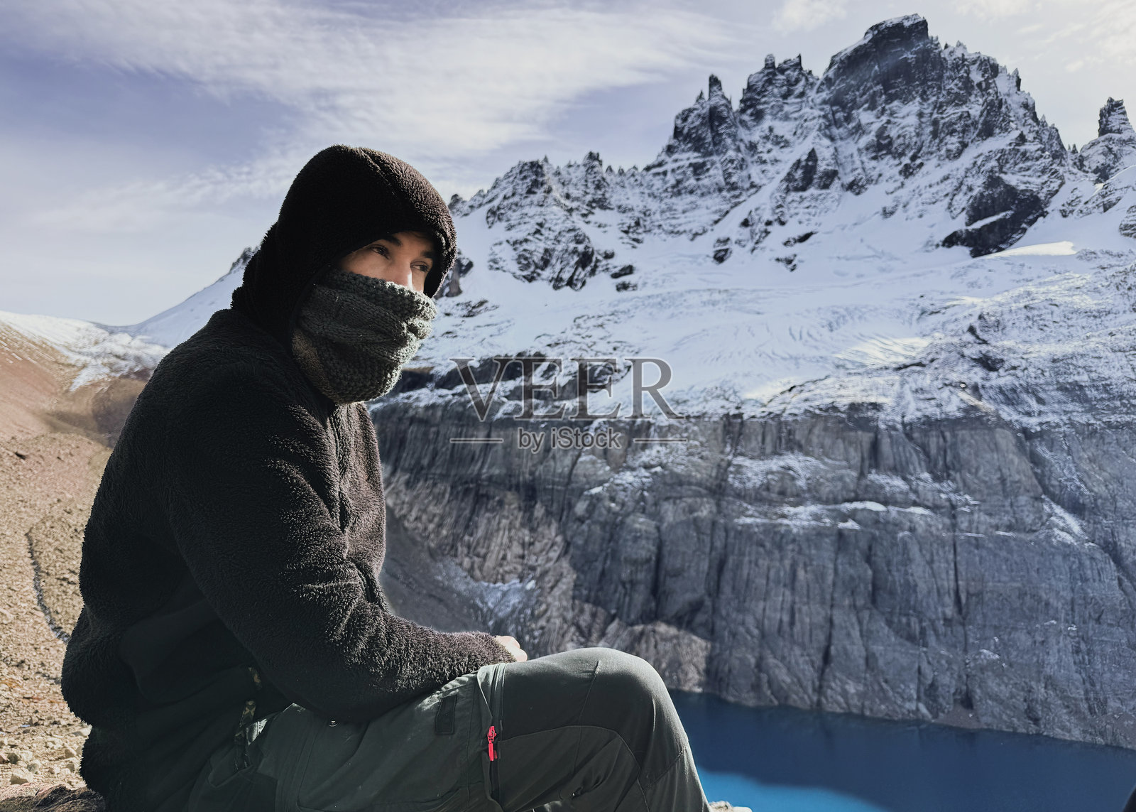 徒步旅行者在欣赏雪山和碧蓝湖泊时休息照片摄影图片