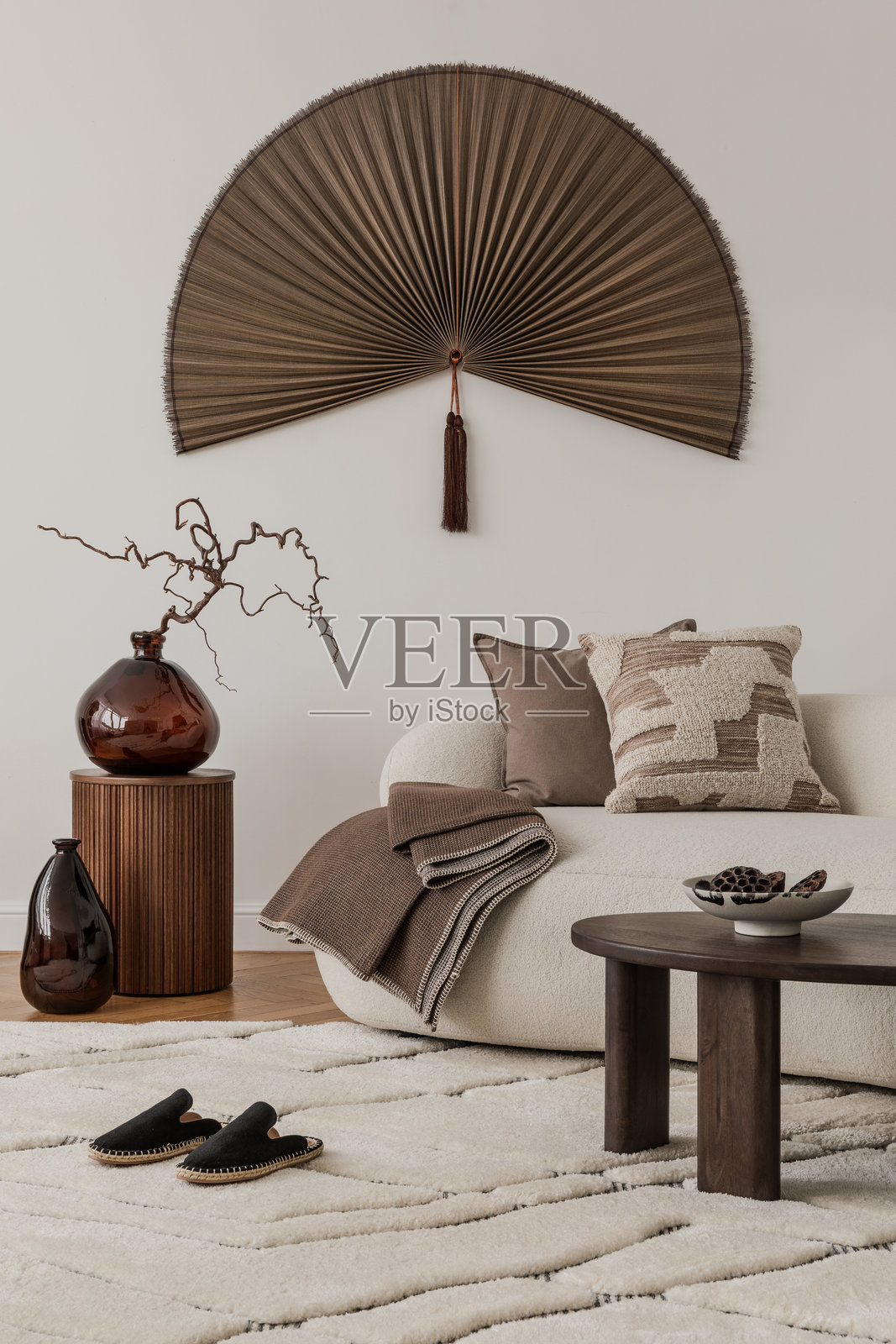 中性风格的居住空间，配有木质边桌、陶瓷蜡烛台和一根绿叶枝。照片摄影图片