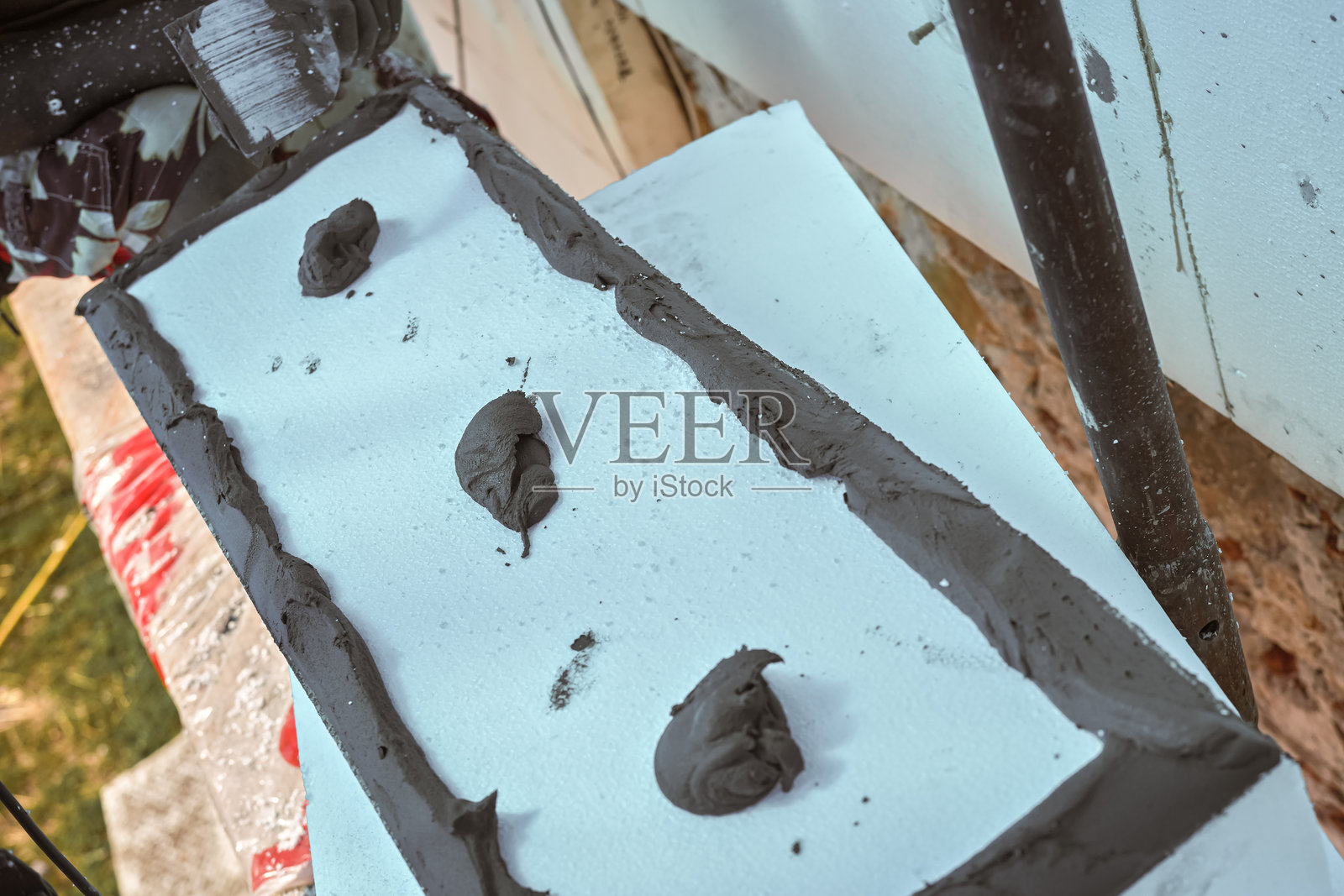 安装白色聚苯乙烯保温材料，灰色粘合水泥胶在白色板上的细节照片摄影图片