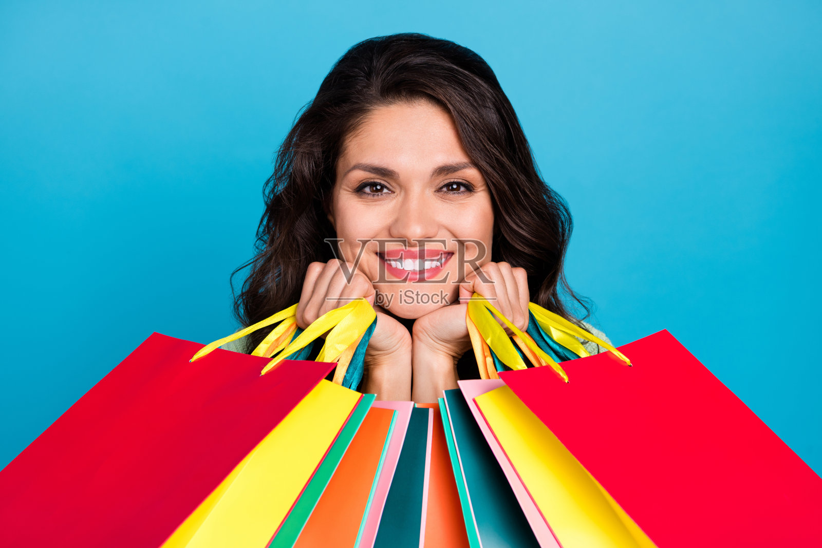 甜美的成熟棕发女士手提包，背景为蓝色照片摄影图片