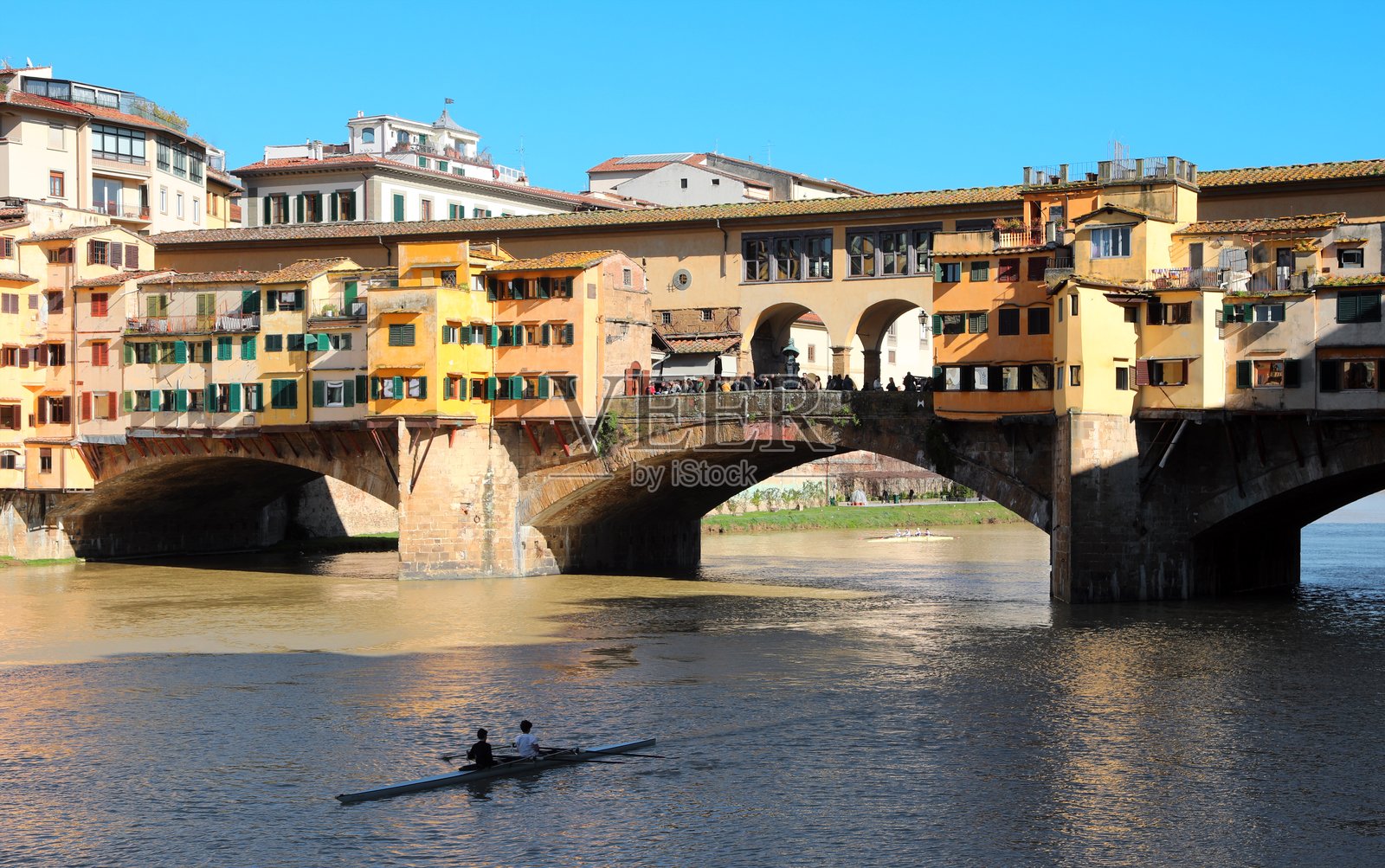意大利佛罗伦萨的著名桥梁PONTE VECCHIO和阿诺河，蓝天和一只独木舟。照片摄影图片