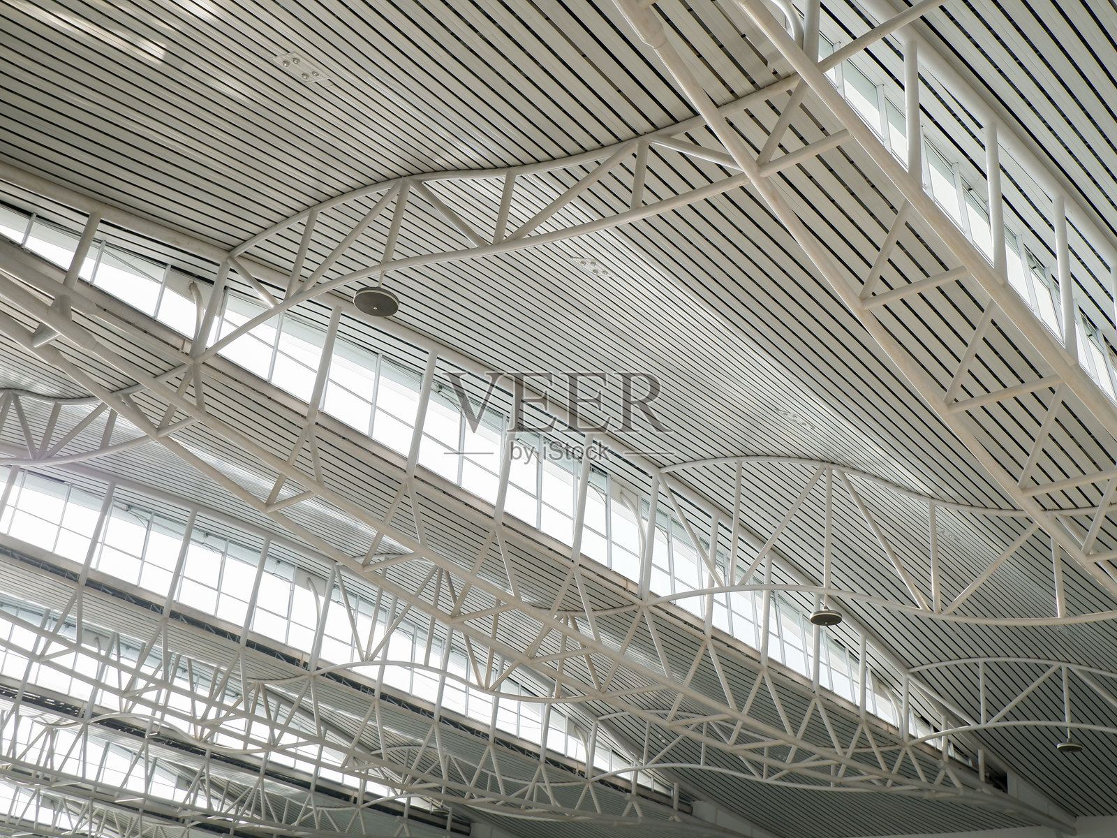 带有悬挂灯泡的钢屋顶桁架结构。通常用于大型建筑设计，如体育场看台和机场。照片摄影图片