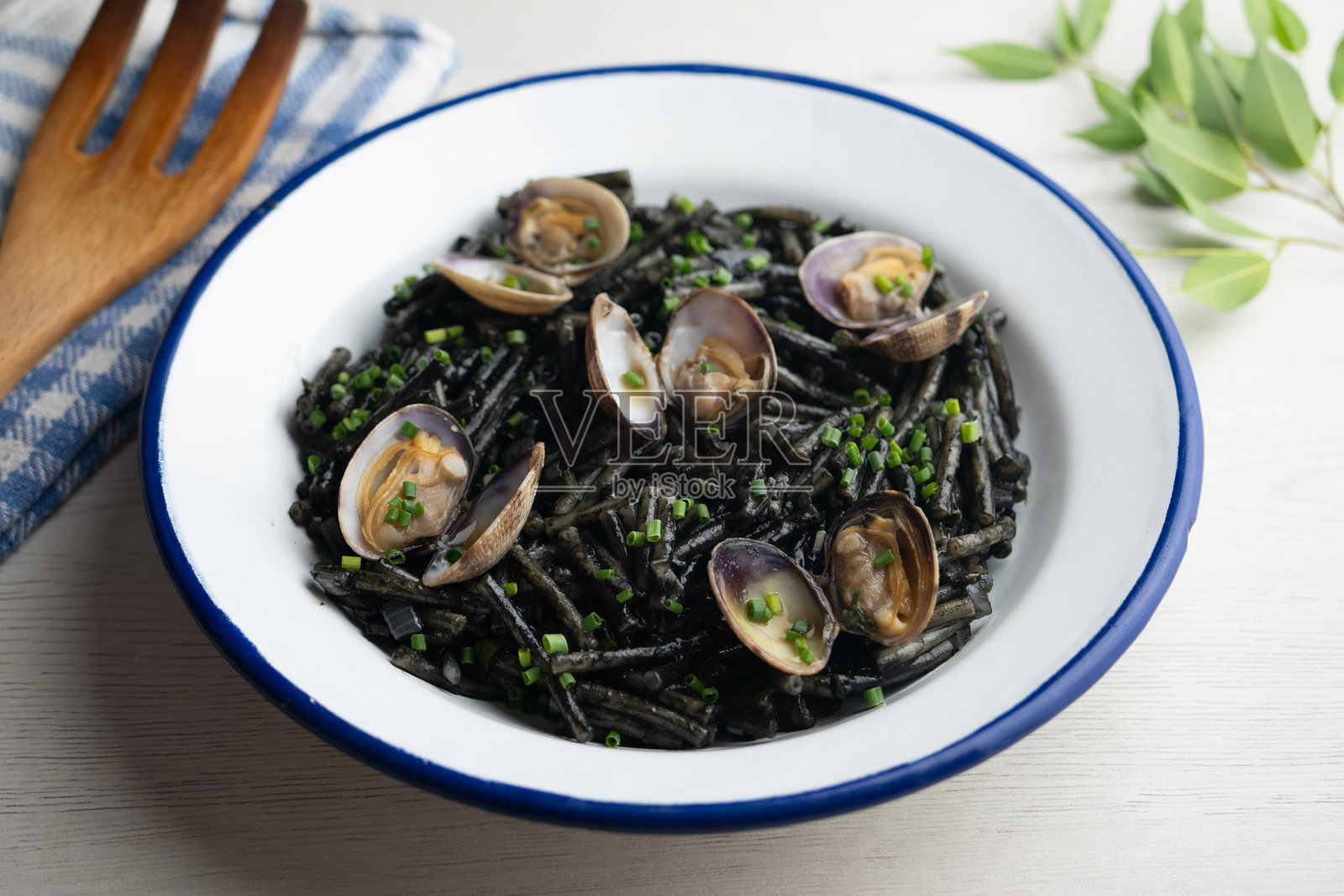 西班牙黑色菲德瓦。传统的西班牙小吃食谱，包含蛤蜊和蒜油的面条。照片摄影图片