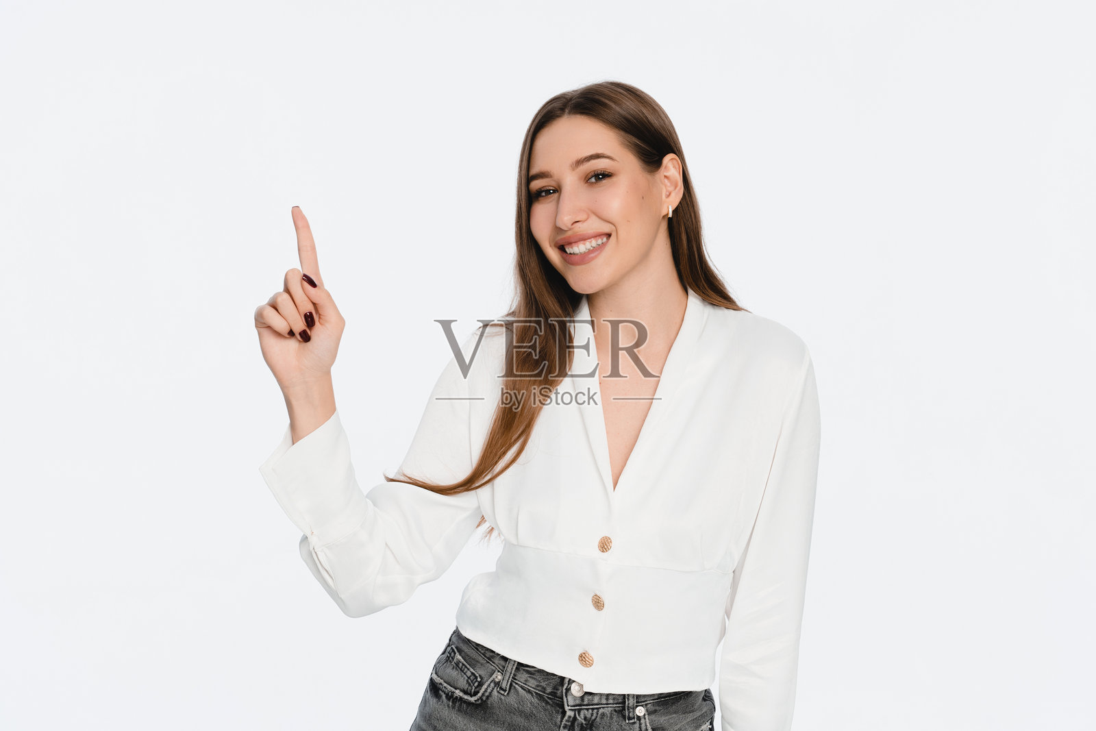 自信的女性微笑着并指向白色背景上的上方照片摄影图片