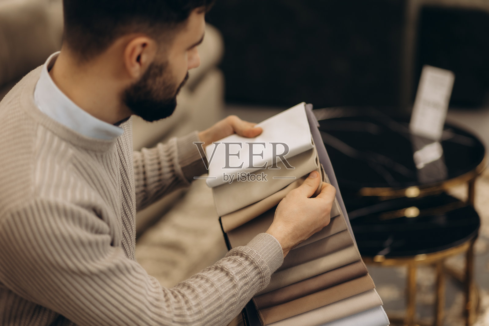 男子在家具店挑选沙发。照片摄影图片