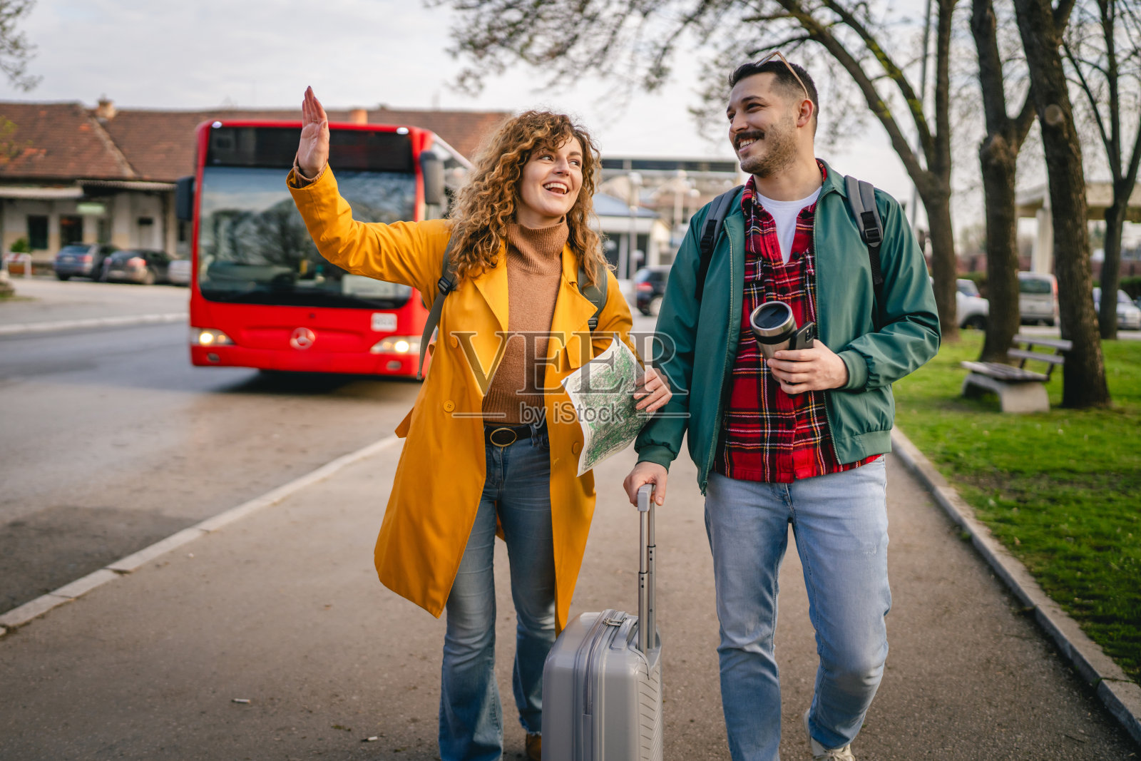 年轻的白人情侣带着行李箱在新城市用地图探索照片摄影图片