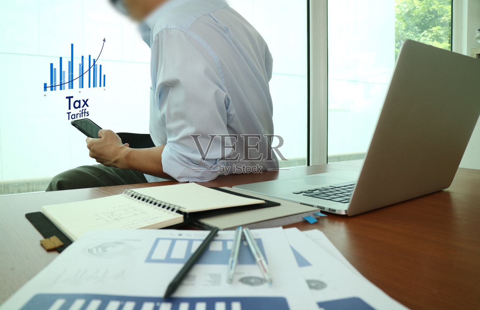 商人使用手机进行税务规划照片摄影图片