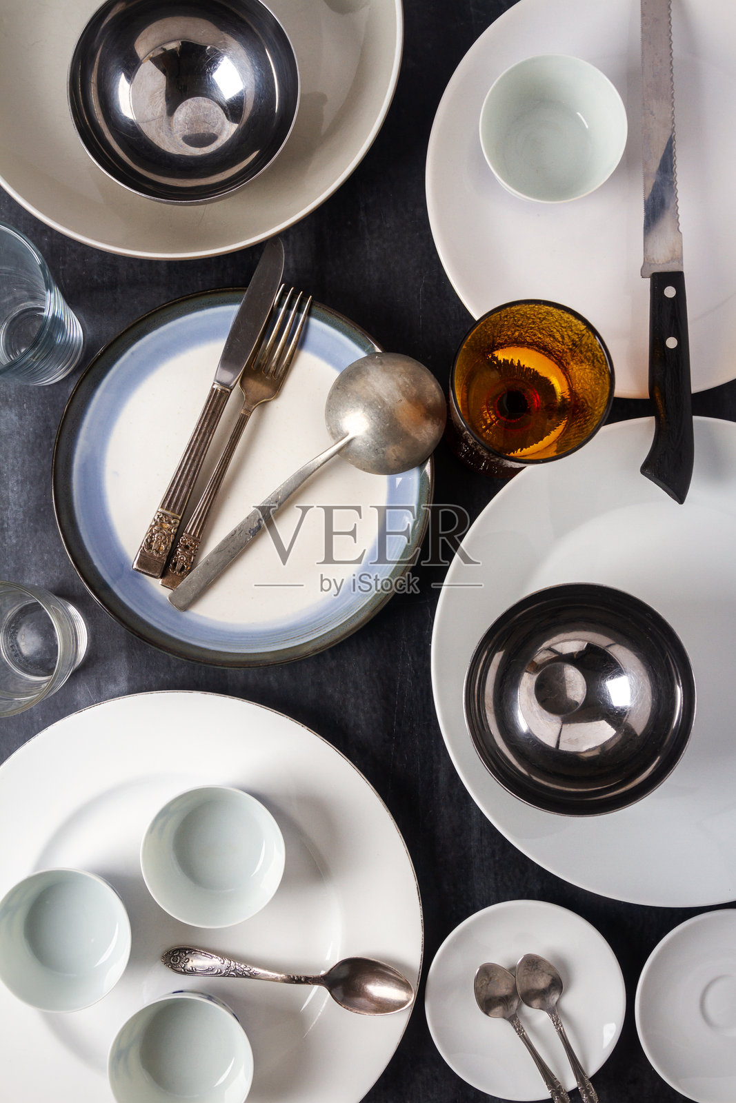 黑色背景上摆放着空盘子、碗、杯子和餐具的俯视图照片摄影图片
