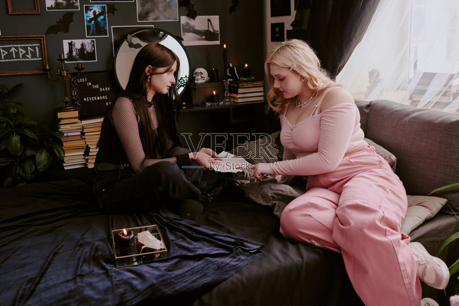 哥特风格的青少年与妹妹一起使用塔罗牌照片摄影图片