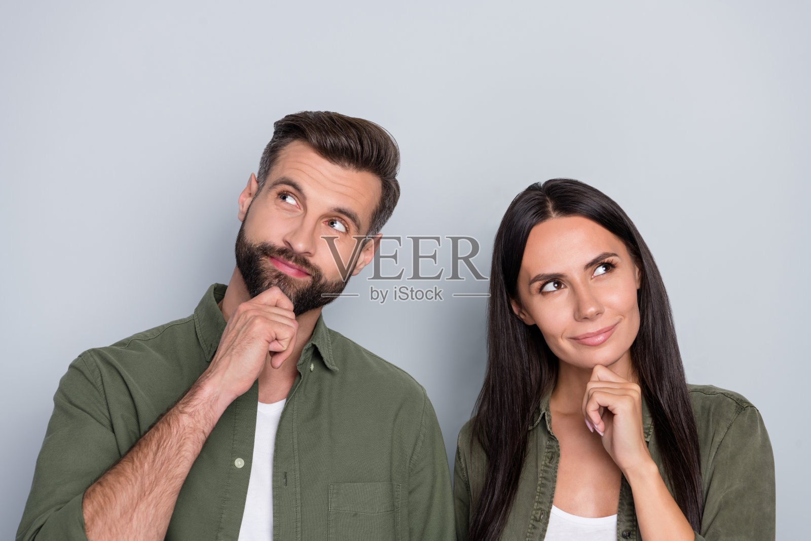 年轻的两个人好奇地望着空旷的空间，心中充满梦想，创意十足，背景为灰色。照片摄影图片