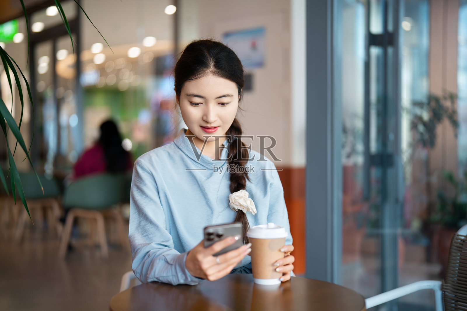 亚洲年轻女性坐在咖啡店里照片摄影图片