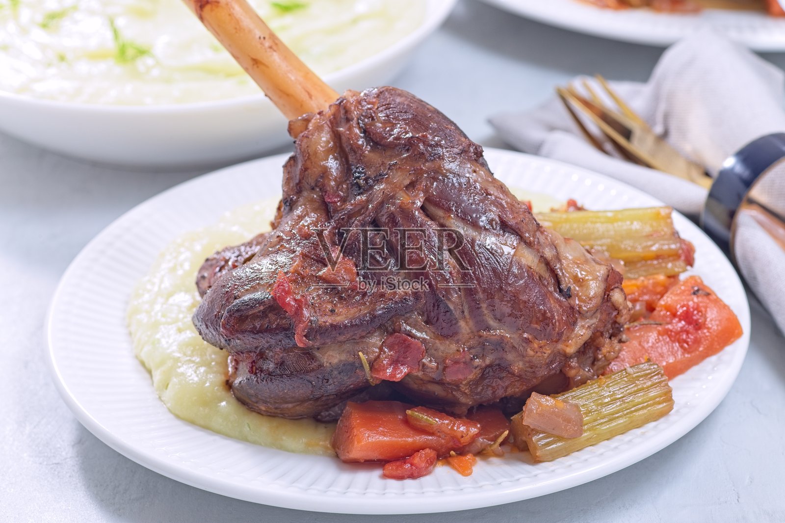 红烧羊腿配蔬菜，搭配辣根和茴香土豆泥照片摄影图片