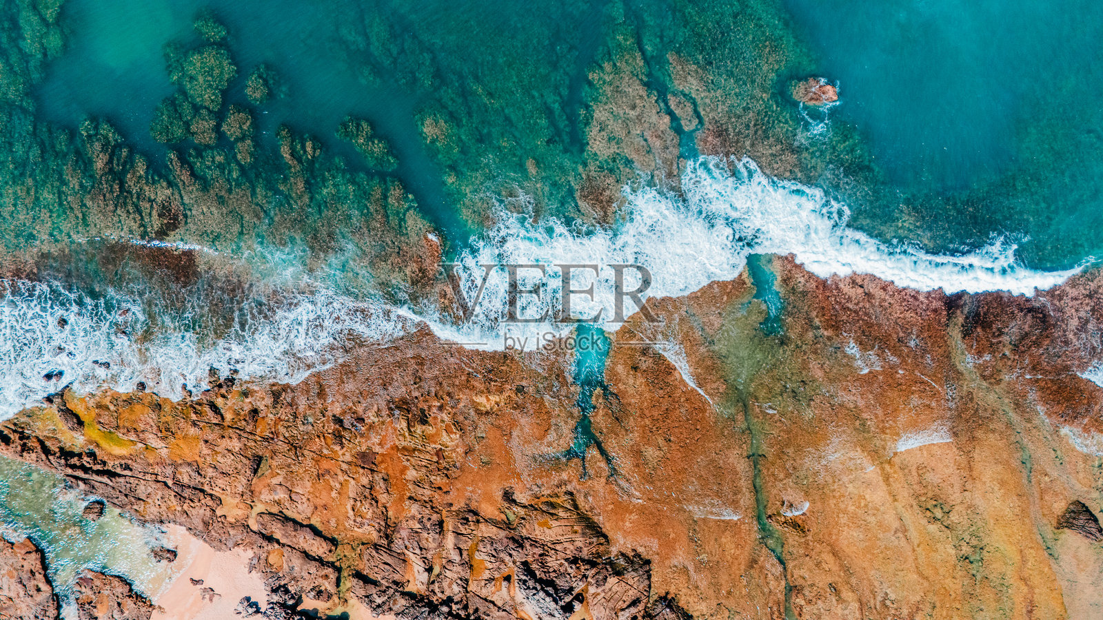 碧绿色的海水拍打着岩石，夏季使用的迷人海岸背景。照片摄影图片