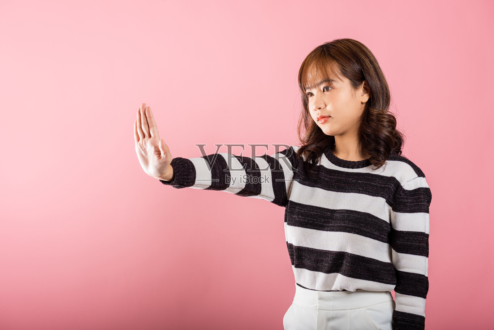 亚洲肖像，漂亮可爱的年轻女性青少年微笑，手掌做出停止手势。照片摄影图片