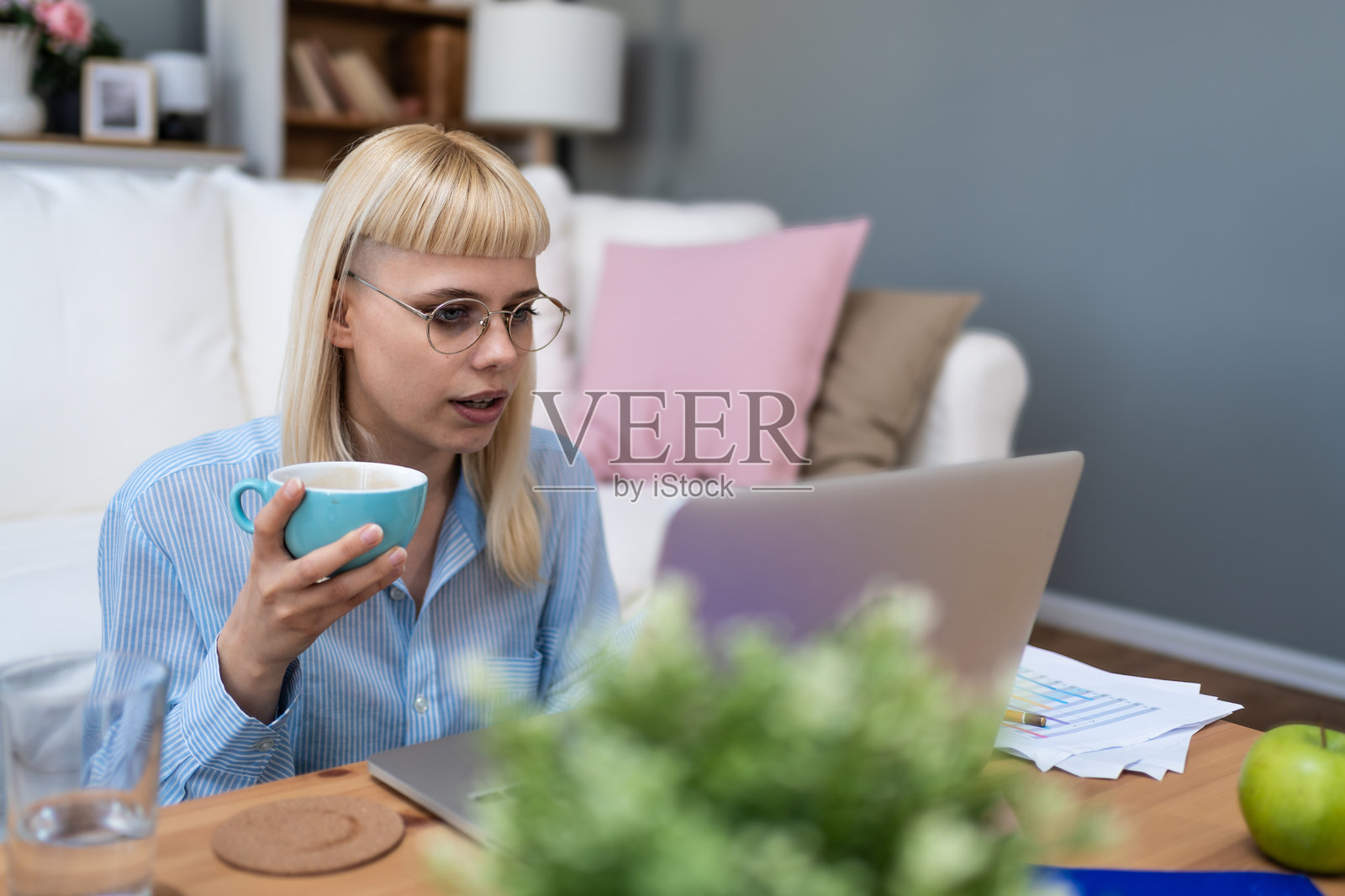 年轻的受过教育的女教师通过笔记本电脑和视频通话在线教授学生。远程教育女性在互联网上帮助年轻学生进行学习课程。照片摄影图片