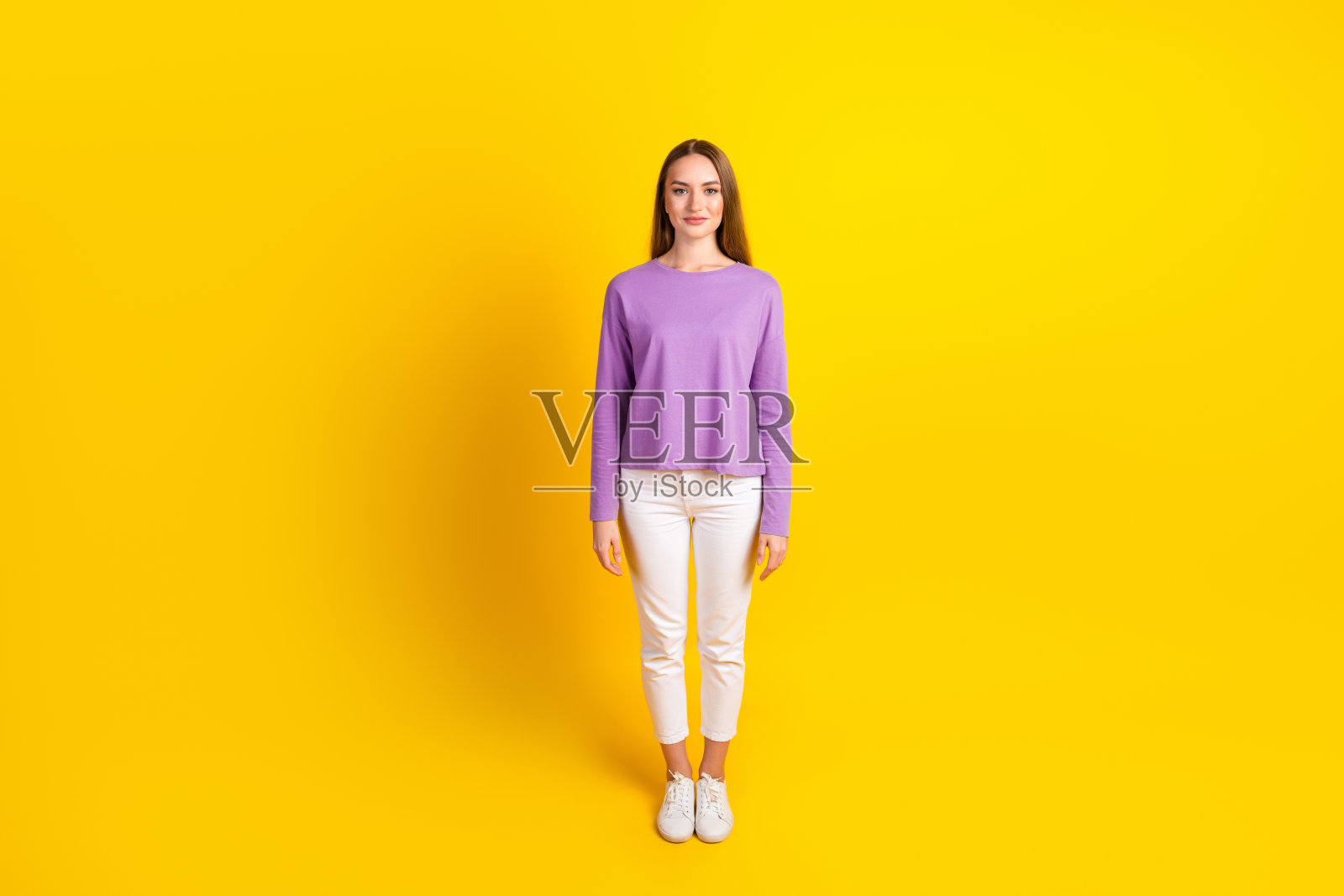穿着紫色毛衣的休闲年轻女性，迷人且时尚，背景为黄色照片摄影图片
