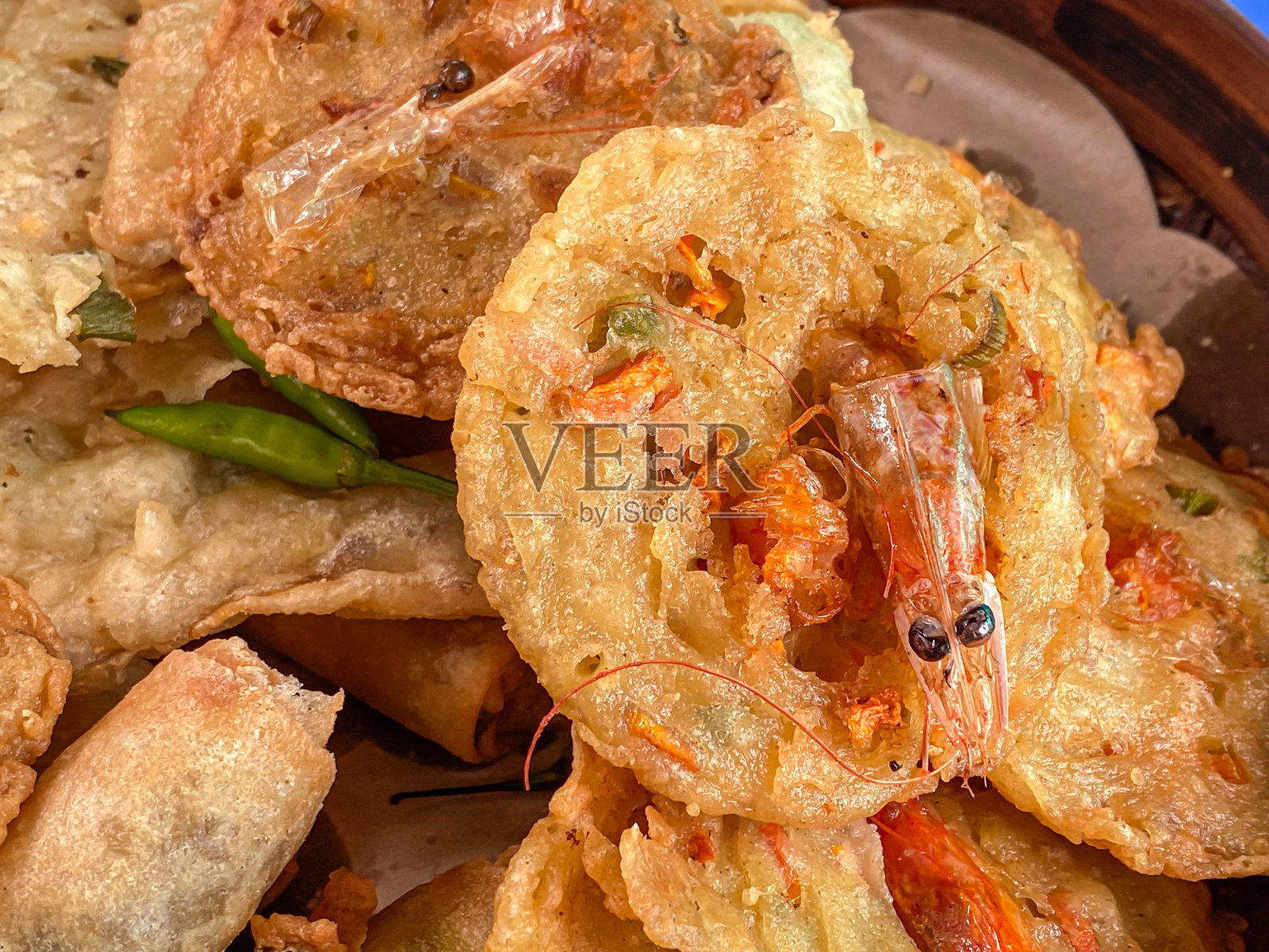 在盘子上盛放的炸巴克万（Bakwan）配以青辣椒，是来自爪哇的传统正宗小吃。照片摄影图片