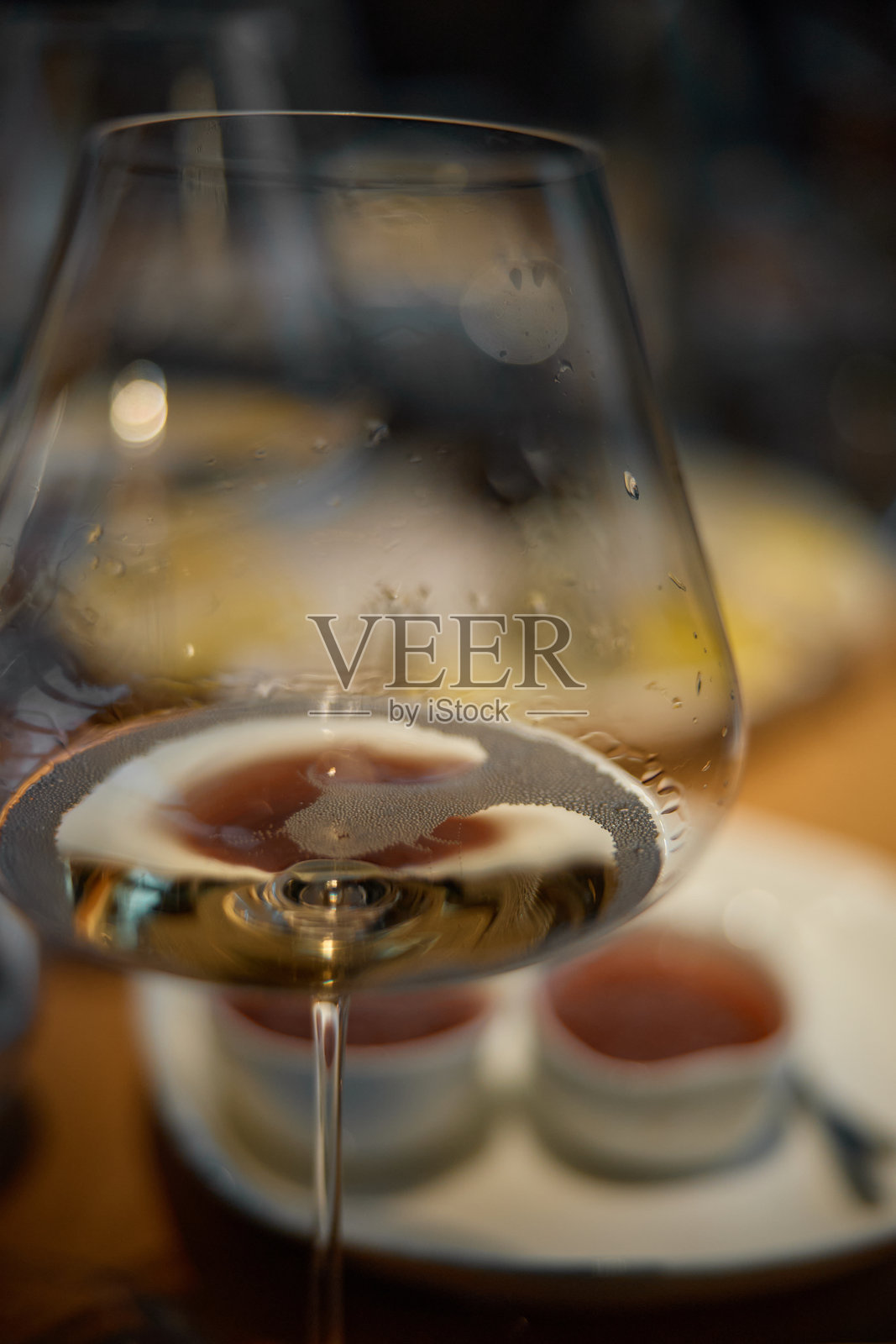 特写镜头中的一杯起泡酒，香槟品尝，桌子上的酒杯，时尚的桌面布置，起泡酒的气泡，生蚝和海胆，特制酱汁照片摄影图片