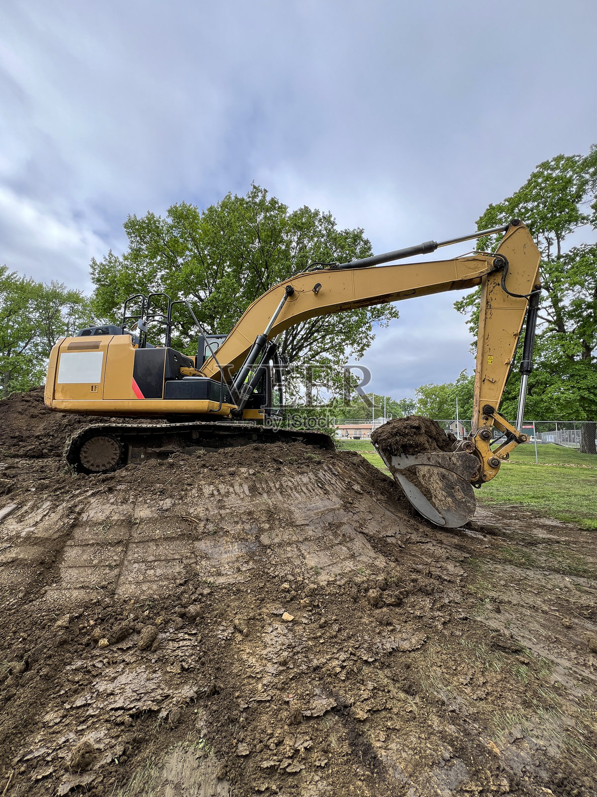 工业挖掘机正在铲起一大堆泥土照片摄影图片