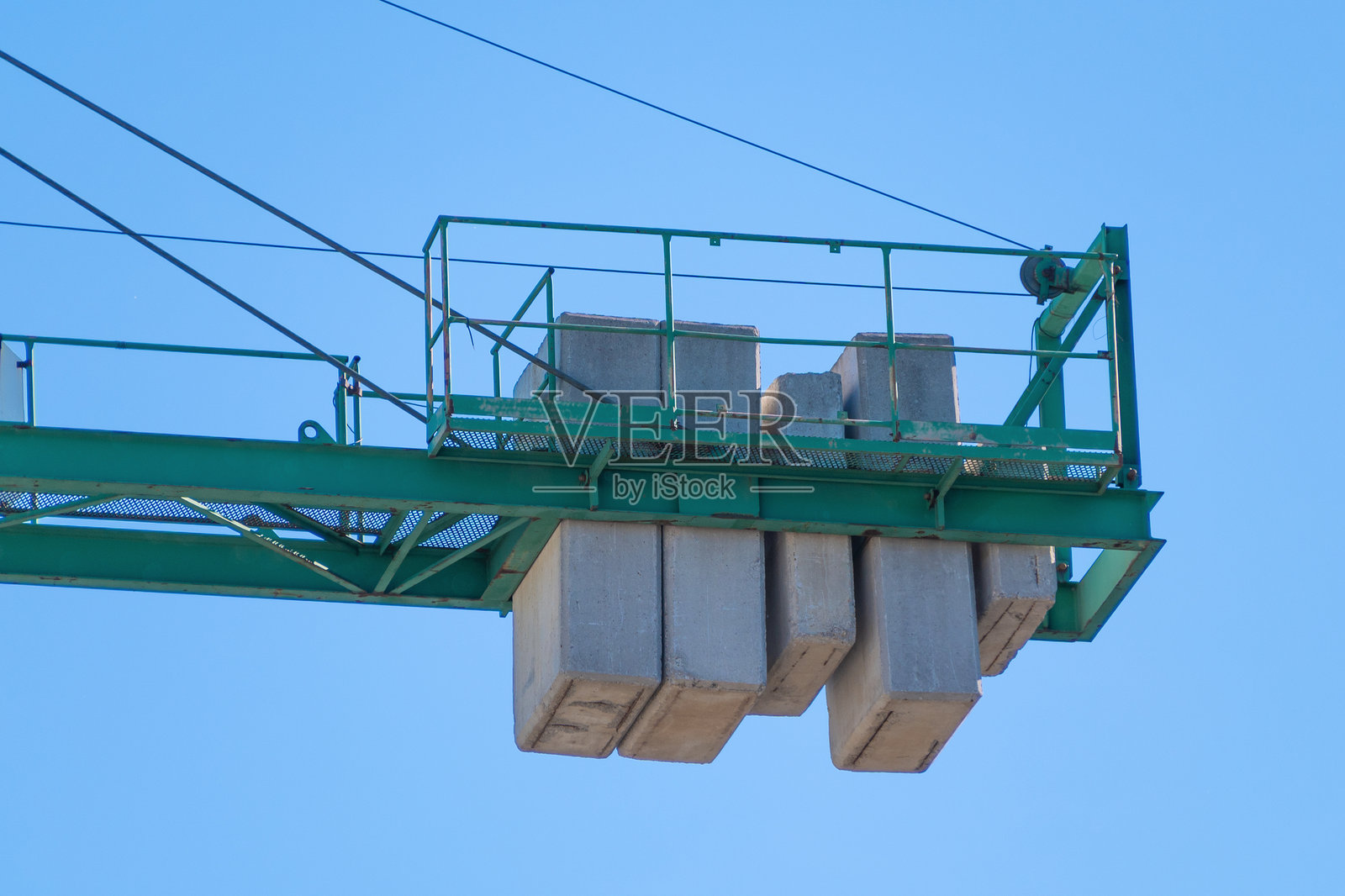 绿色建筑起重机上的平衡重与蓝天相映成趣照片摄影图片