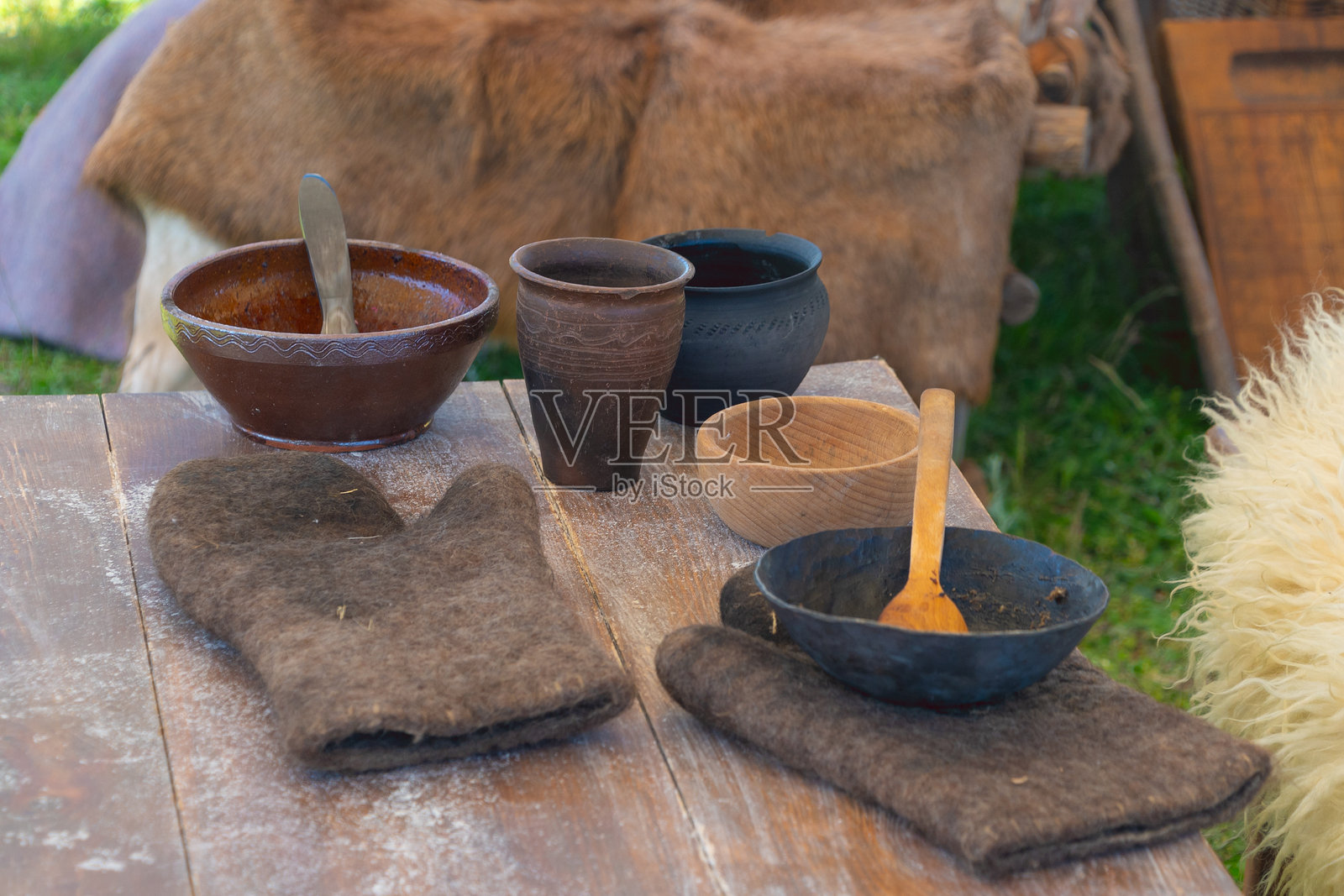 户外环境中木桌上的乡村风格陶土和木质餐具照片摄影图片