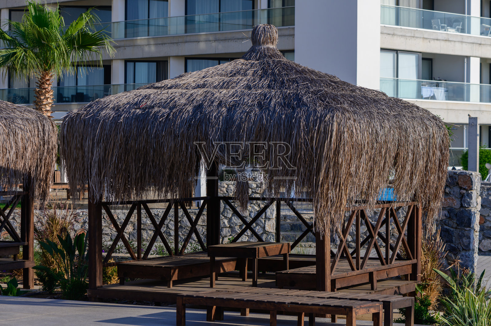 时尚的平房与靠近海滩的绿松石游泳池，位于塞浦路斯。完美的夏日度假胜地，伴有棕榈树和海风。照片摄影图片