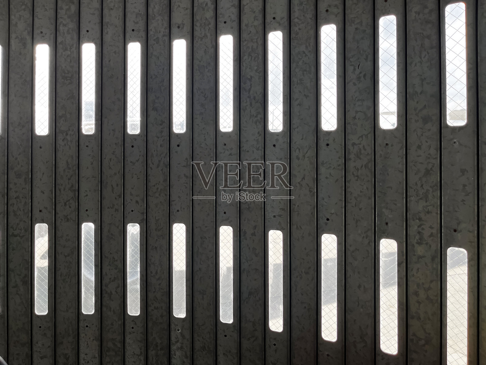 对称的钢墙，带有垂直缝隙窗和钢丝网玻璃照片摄影图片