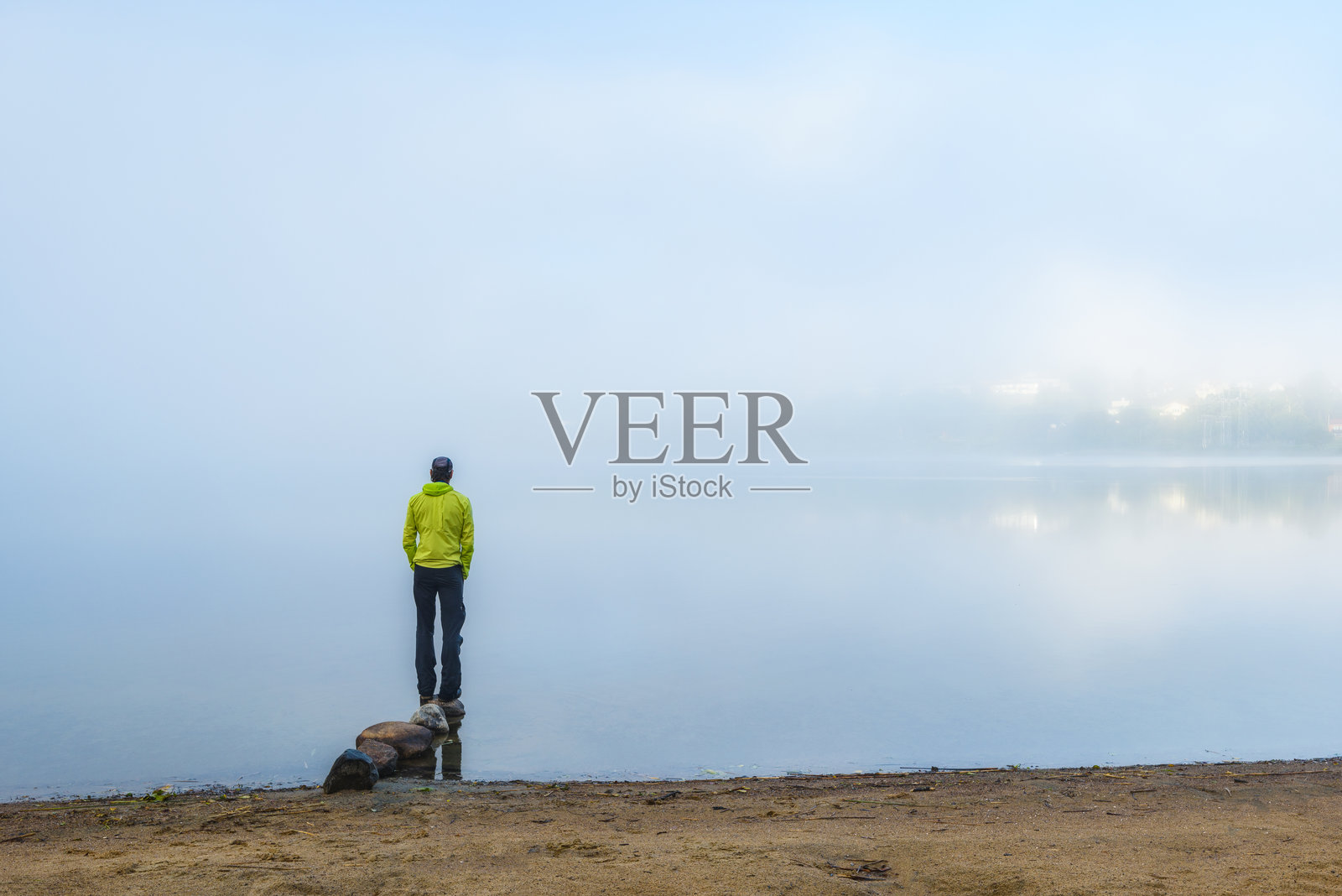 孤独的男人在宁静的早晨凝视着莫尔达尔的一片雾蒙蒙的湖泊照片摄影图片