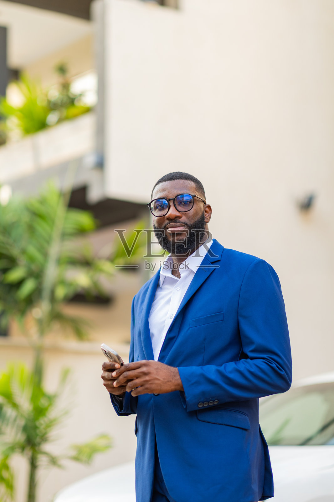 年轻的非洲男子在户外使用智能手机。照片摄影图片