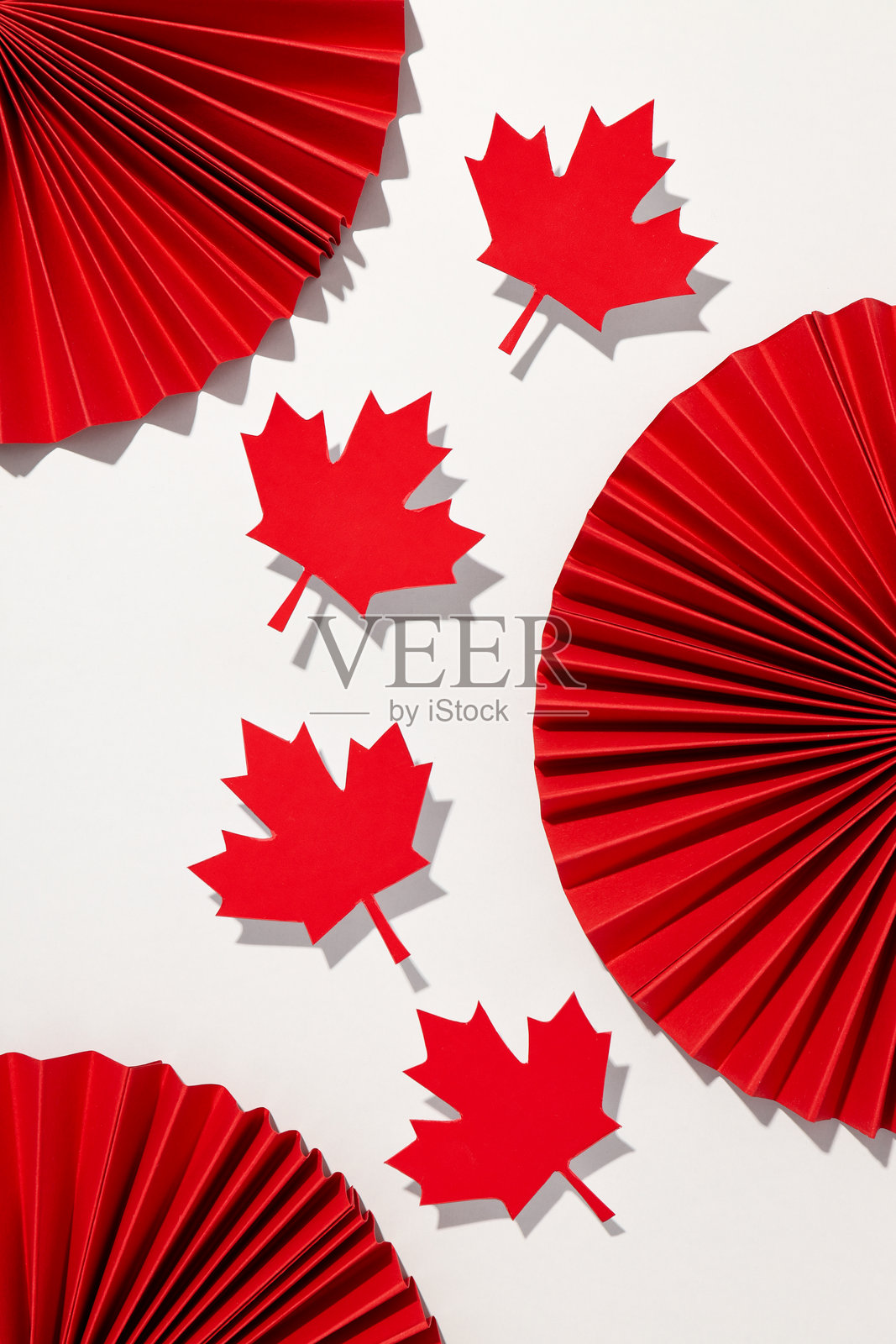 红色纸质枫叶与装饰品在浅色背景上照片摄影图片