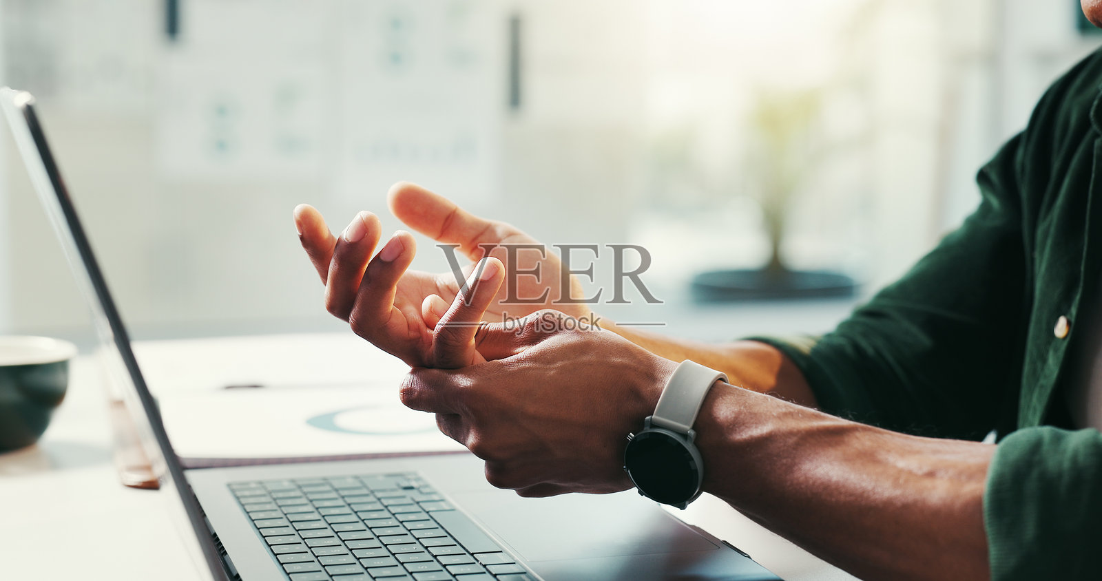 男性在办公室中因打字受伤而感到手部疼痛，笔记本电脑导致腕管综合症的紧张和炎症。男性，肌肉拉伤和工作场所的键盘事故，关节受伤和职业性关节炎。照片摄影图片