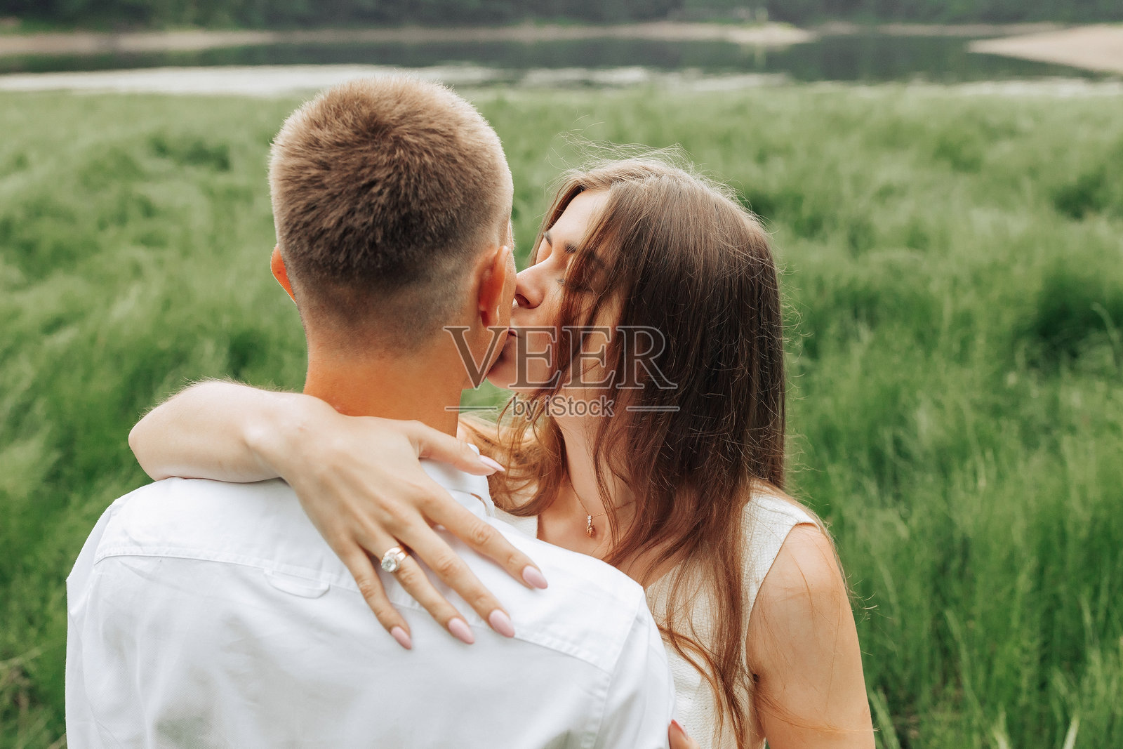 一男一女在田野中亲吻照片摄影图片