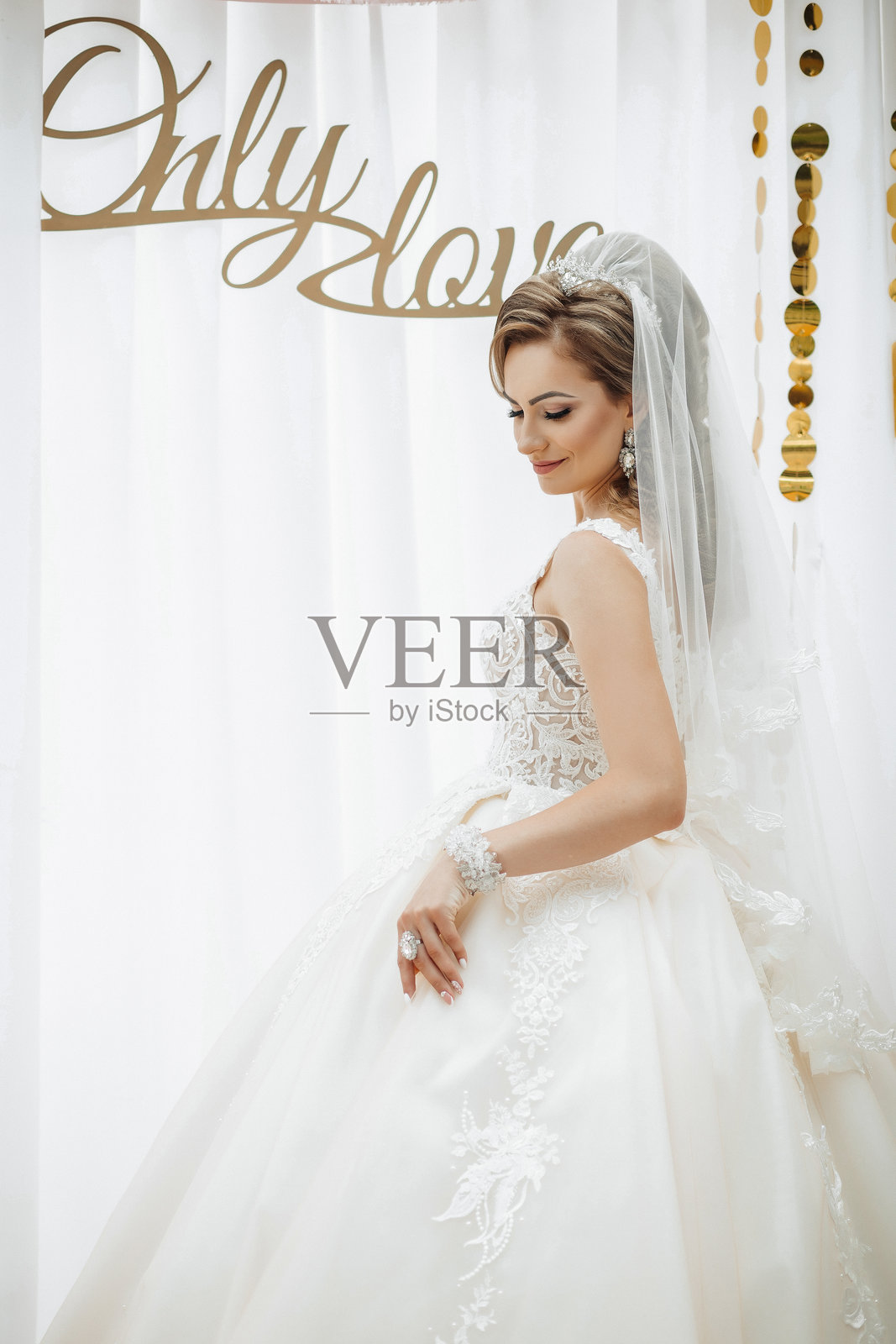 一位穿着白色裙子的女性站在写着“只有爱”的标志前。照片摄影图片