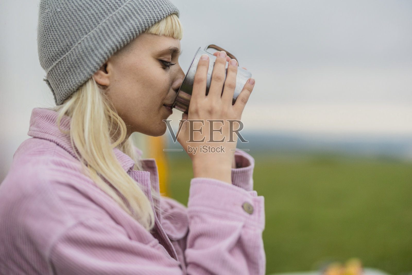 露营者在大自然中用金属杯喝热饮照片摄影图片