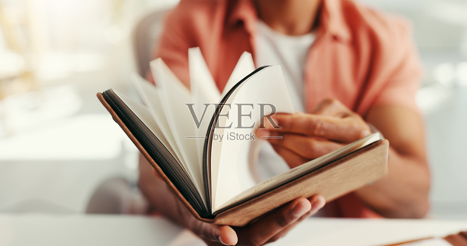 Book, hands and pages with business person at desk in office for calendar, reminder or schedule. Diary, journal or notes with design employee in creative workplace for development or planning照片摄影图片