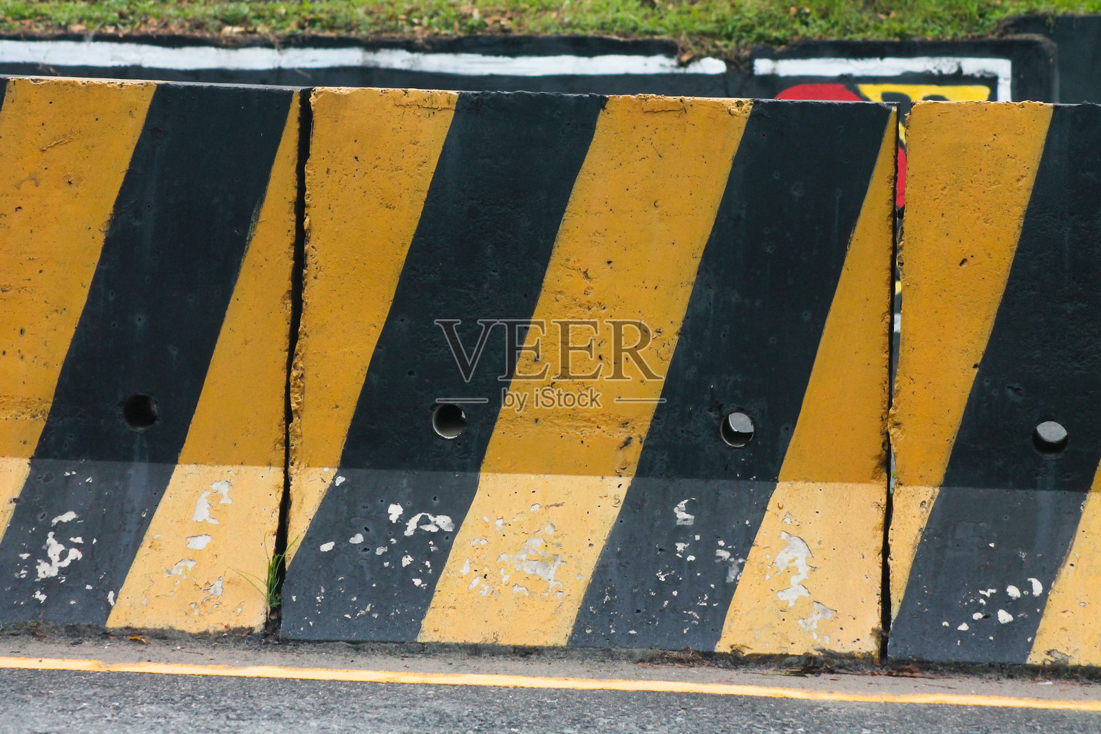 黄色和黑色的临时混凝土路障分隔器。照片摄影图片