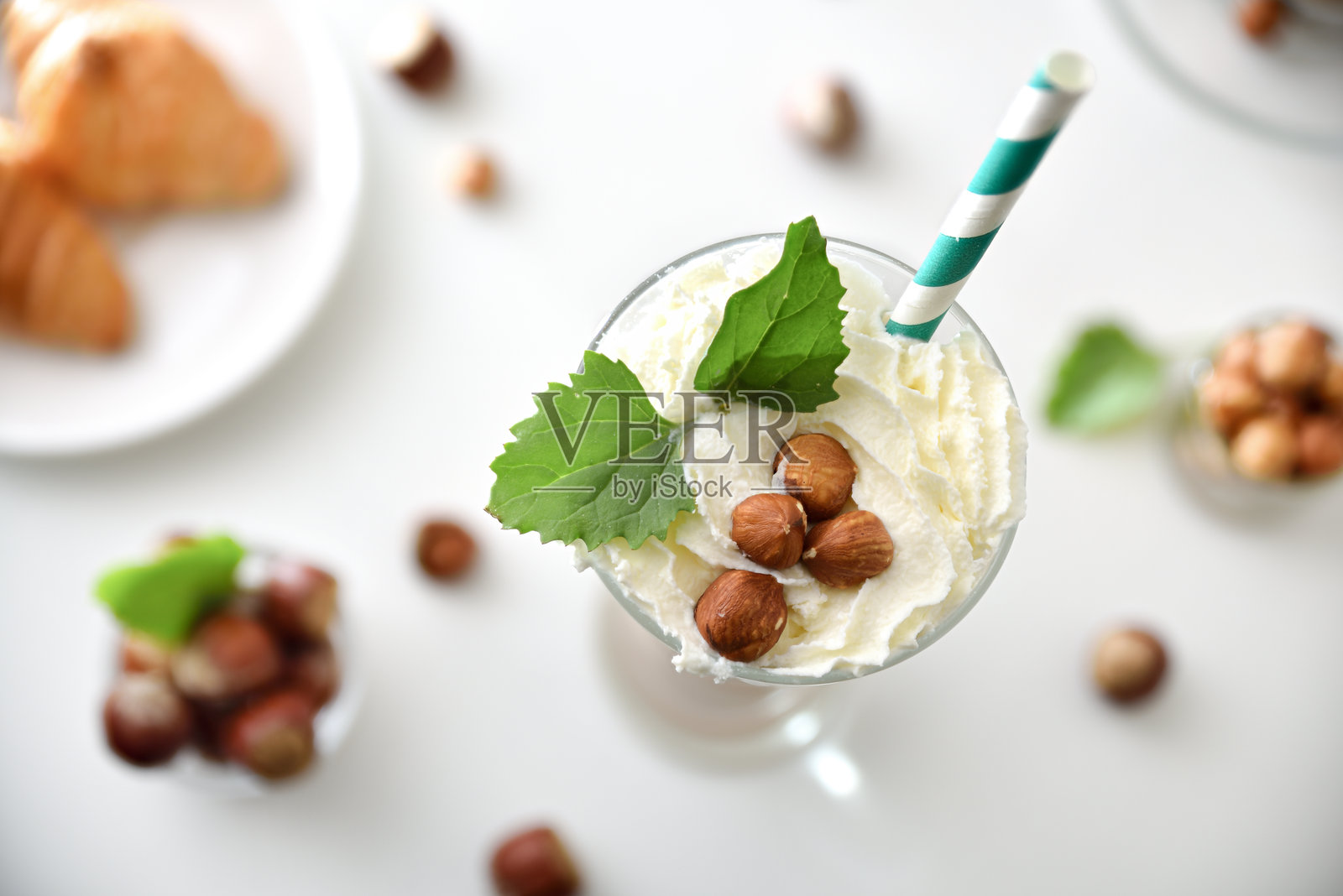 带奶油和吸管的榛子奶昔玻璃杯特写照片摄影图片