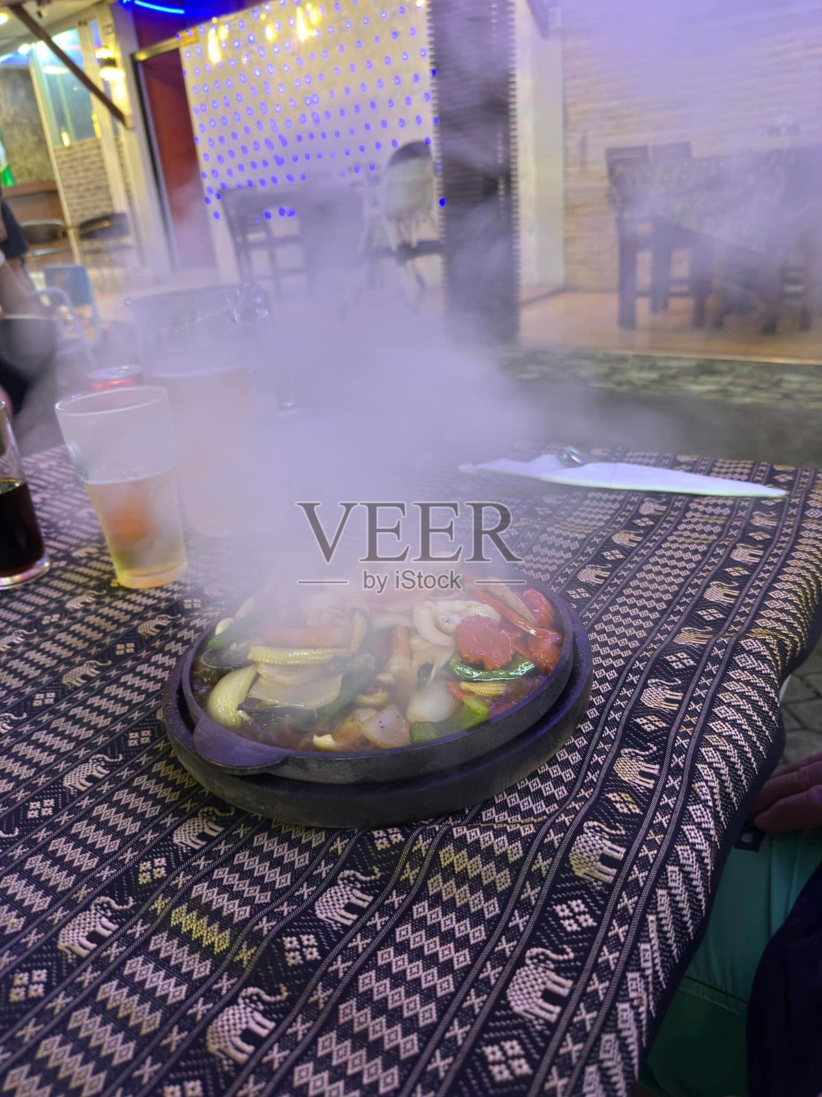 夜晚色彩斑斓的户外餐桌上，热气腾腾的新鲜蔬菜和香料拼盘照片摄影图片