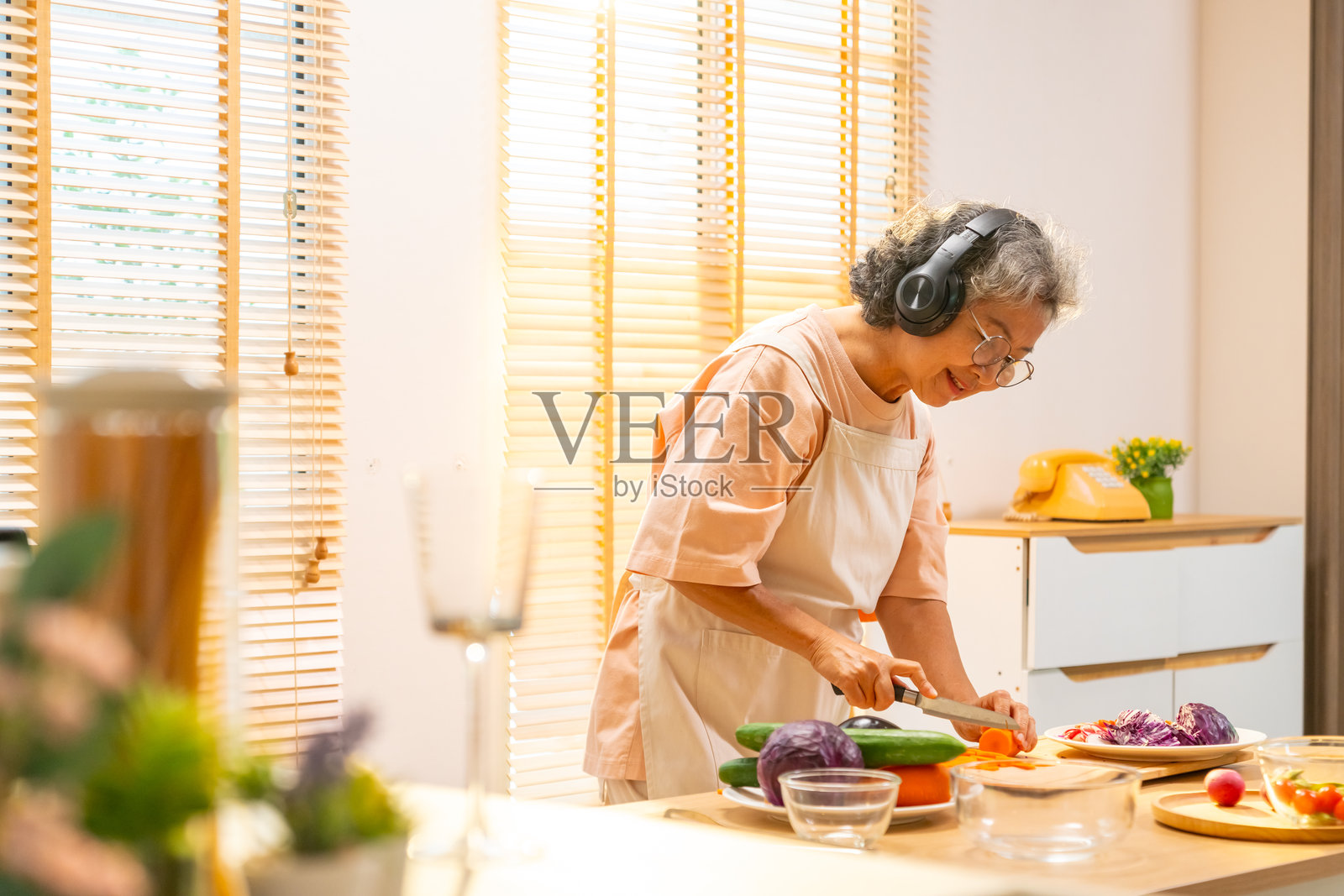 亚洲老年女性在家中烹饪。照片摄影图片