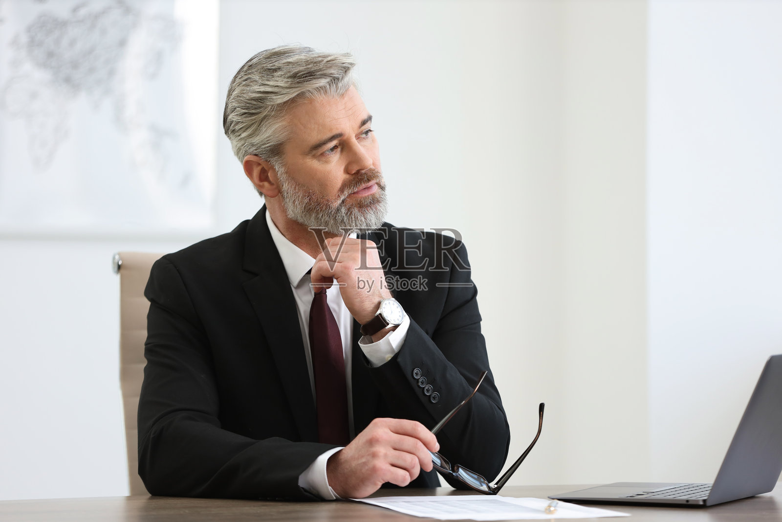 戴眼镜的银行家在办公室的桌子前照片摄影图片