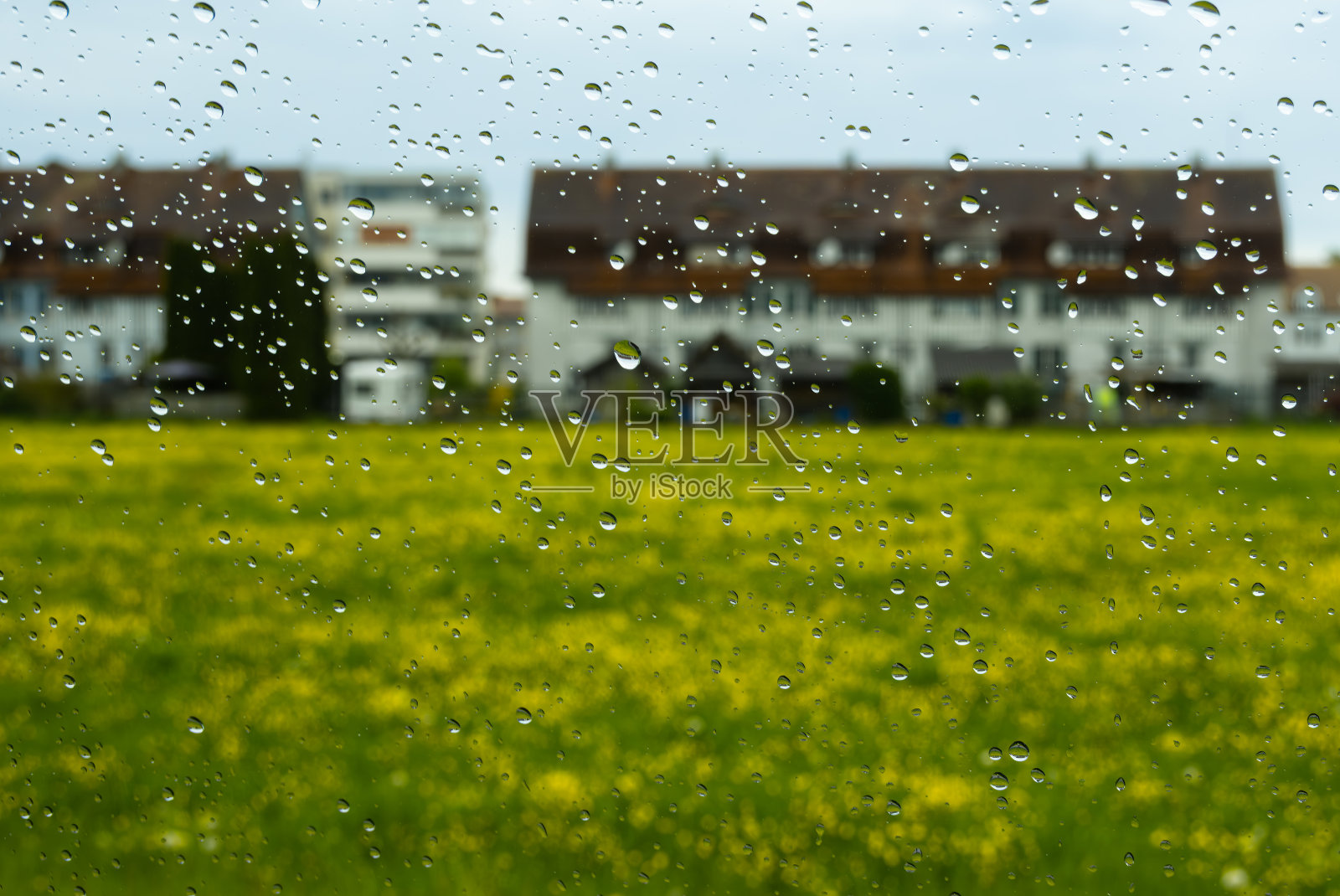 窗户上的雨滴，俯瞰房屋和田野照片摄影图片