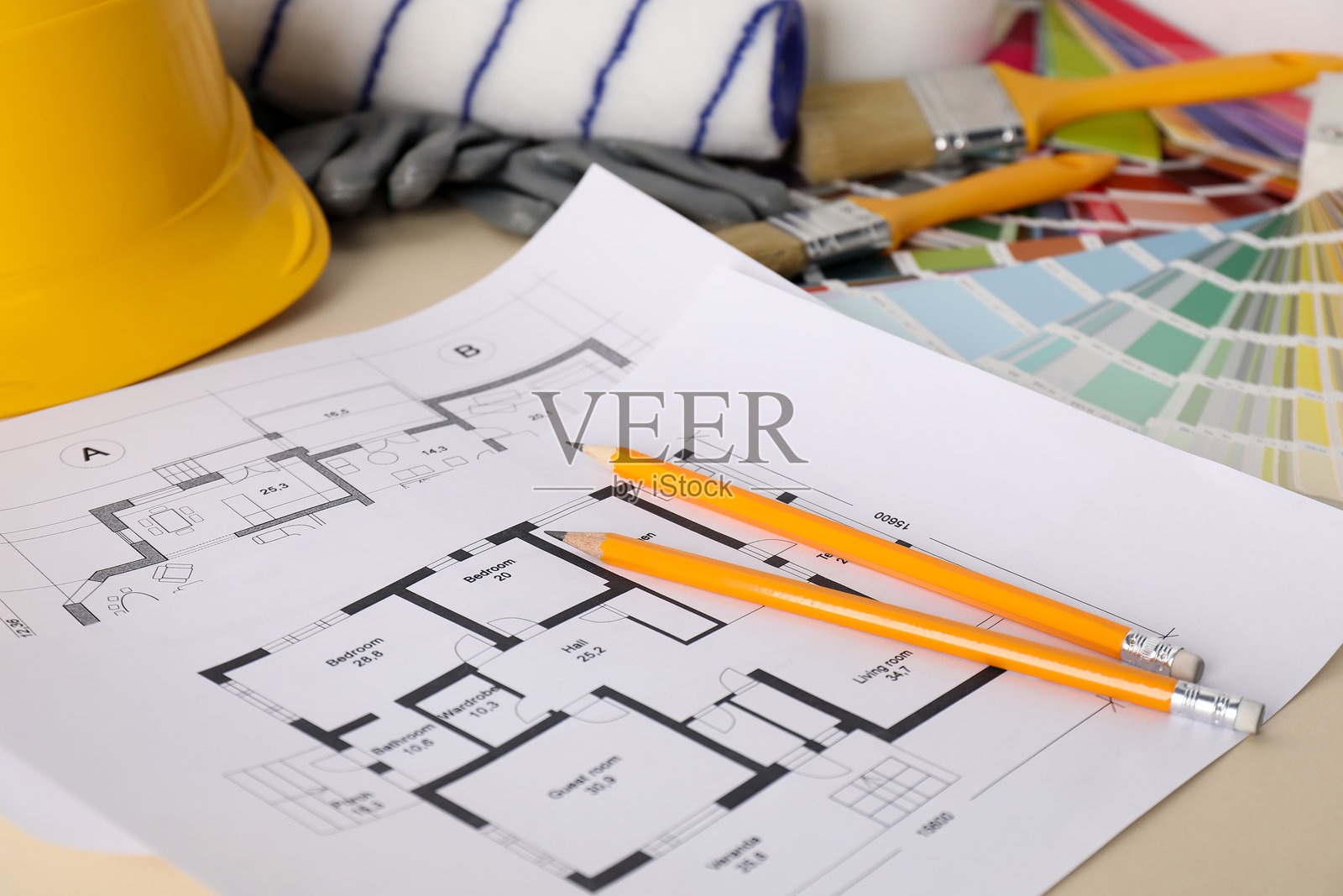 米色桌子上的房屋设计图和各种装饰工具，特写镜头照片摄影图片