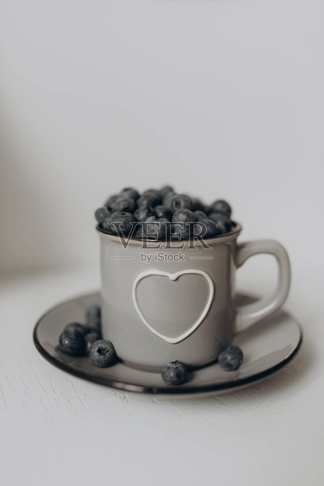 一个装满新鲜蓝莓的杯子放在干净的白色背景上照片摄影图片